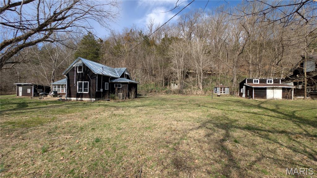 Nestled in the historic Cooper Hill area, this one-of-a-kind 3 bedroom, 1 bath property offers a rare opportunity for investors and visionaries alike. Tucked along a stunning rock bluff, the setting alone sets this property apart—featuring native stone walls, an old smokehouse, and a spring-fed cave with continuously flowing water.

This is the kind of property that can’t be recreated. The natural features and rustic charm create a highly desirable backdrop for a short-term rental or weekend getaway destination.

The home itself is full of character, with a wood-burning fireplace, loft space, and a layout ready to be reimagined. While it does need TLC, the potential is clear—whether you're looking to renovate and flip or transform it into a unique Airbnb or VRBO experience.

With the growing demand for private, nature-focused stays, properties like this—with a bluff, cave, and historic charm—offer strong appeal to guests looking for something beyond the ordinary.

Additional outbuildings provide space for storage, workshop use, or future enhancements to further increase value and functionality.

Whether you're an investor looking for your next project or someone ready to create a one-of-a-kind retreat, this property is packed with opportunity and upside potential.