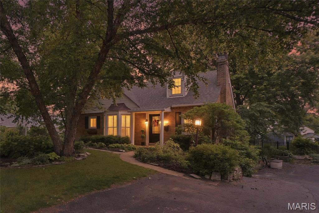 Adorable, airy, and brimming with charm, this delightful 1.5-story home in the heart of Webster Groves offers over 1,500 square feet of inviting living space. From the classic white post-and-rail fence to the beautifully landscaped grounds, the curb appeal is simply irresistible. Inside, timeless character blends beautifully with bright, welcoming spaces. The inviting living room is filled with cottage charm, featuring beautiful cottage-style windows, while the sun-drenched dining room showcases a stunning bay window with plantation shutters. The kitchen offers a gas range, center island, and abundant cabinetry, flowing effortlessly into the cheerful family room where natural light pours in, creating an ideal space for everyday living and entertaining. A versatile main-floor bedroom is complemented by an adjoining bonus room—perfect as a home office, cozy reading nook, sitting room, or future walk-in closet. Upstairs, you'll find two generously sized bedrooms and a full bath thoughtfully situated between them. Step outside to discover a backyard that feels like your own private retreat. Mature landscaping and lush gardens surround a beautiful flagstone patio, creating the perfect backdrop for morning coffee, evening dinners, entertaining friends, or simply unwinding at the end of the day. A one-car tuck-under garage provides convenient parking for a compact vehicle or additional storage.
Thoughtfully refreshed while preserving its timeless character, this charming Webster Groves home is filled with warmth, personality, and inviting spaces you'll love coming home to.