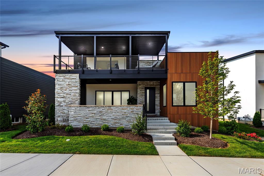 Experience elevated lakefront living in this spectacular, nearly new 1.5-story custom home located in Chesterfield's exclusive Waterfront at Wildhorse Village. With over 4,800 sq ft of curated living space, this 5 bed, 5 bath (4F/1H) residence showcases a sun-drenched open floor plan with 10' ceilings, wide-plank white oak flooring, designer millwork & dramatic lake views from nearly every room. Gourmet kitchen features high-end appliances, a Sub-Zero fridge, waterfall-edge island, floor-to-ceiling custom cabinets & fully integrated wine sommelier station. Main-level primary suite offers a private retreat with a spa-like bath, rainfall shower, soaking tub, dual vanities & custom closet. Upstairs includes a junior suite, two additional beds, another full bath, bonus room with wet bar and wine fridge & access to a covered lakeview deck. Finished lower level is built for entertaining with a second kitchen, custom bar, fitness room, bedroom, full bath & designer acoustic accent wall. Outdoor living is unmatched with a covered front lanai, second-floor deck & private courtyard featuring stone pavers, 8ft custom fire table & 145" triple weir waterfall. Additional features include a full smart home system, window treatments, security cameras, irrigation, professionally landscaped yard, tons of storage, and a 3-car garage with epoxy floors & custom cabinets. Located steps from walking trails, 2 lakes & minutes to premier dining, shops & hwys - this is luxury living redefined!