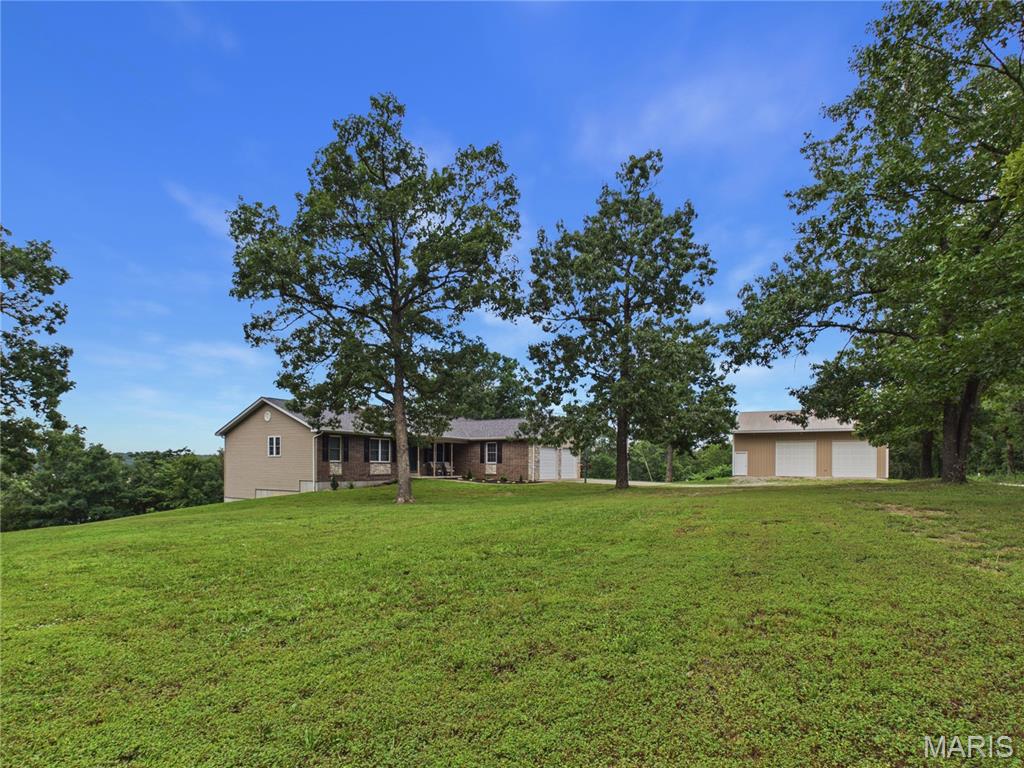Welcome to your private country retreat on 3 picturesque acres surrounded by a mature tree line for added privacy.  Where quality craftsmanship, energy efficiency, and exceptional functionality come together. This custom-built home features Energy Star windows, LED lighting, spray foam insulation throughout, a private well, and lagoon system for added efficiency. You will also appreciate the year-round comfort provided with energy-efficient heat pump system. 

Inside, you'll find beautiful bamboo flooring with custom inlay detailing, upgraded lighting, tasteful finishes, and a thoughtfully designed floor plan. The spacious living room, kitchen and formal dining room, provide both comfort and convenience for everyday living.  Kitchen includes new refrigerator and dishwasher. 

The main level offers a luxurious primary suite complete with a jetted tub, separate custom-tiled shower, and walk-in closet, along with two additional bedrooms and a full guest bath. The fully finished walkout basement expands the living space with two more bedrooms, a full bath, an expansive family room, recreation area with pool table, wet bar, second kitchen/prep area, abundant storage, and a storm shelter. A sixth non-conforming bedroom provides additional flexibility for guests, hobbies, or a home office. 

Outside, hobbyists, entrepreneurs, and outdoor enthusiasts will appreciate the insulated and heated 30x40 shop, dedicated John Deere garage, 335-foot fully cased well, 80-gallon water softener, and numerous additional upgrades throughout the property including brand new roof in February of 2026 and brand new, expansive 44ft x 12ft deck to be built prior to closing, providing you with exceptional views of your property and additional peace of mind! Offering space to live, work, entertain, and enjoy the outdoors, this one-of-a-kind property truly delivers! 

Don't miss your opportunity to call this place home! Schedule your showing today!