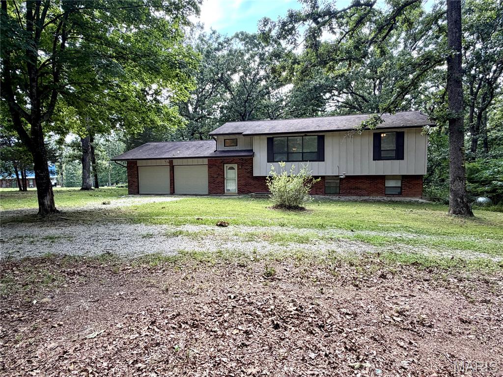 Tucked in the trees on 2.93 acres less than 3 miles from town, this spacious 4-bedroom, 2.5-bath split-level offers the perfect combination of privacy and convenience. The open main level features a large living room, dining area, and updated kitchen with an electric range, refrigerator, dishwasher, updated countertops, and abundant cabinetry with two Lazy Susans. The expansive back deck is perfect for entertaining or enjoying the peaceful, wooded setting. The main level also includes two bedrooms, including the primary suite with a private bath. The walkout lower level offers a cozy family room with a wood-burning fireplace, built-in bookcases, two additional bedrooms, a full bath, and laundry/utility room. The home features central A/C with propane forced-air heat, plus a propane wall unit in the lower level for backup heat and an attic fan for added efficiency. Step outside to the concrete patio and spacious backyard with plenty of room to relax. If you're looking for peaceful country living with room to spread out just minutes from town, this is the one! Schedule a private showing today!