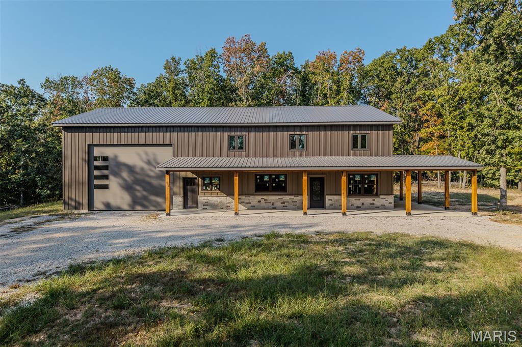 Tucked away on 15 secluded acres just 6 miles from town and only minutes from Bennett Spring State Park, this incredible barndominium offers the perfect blend of privacy, nature, and endless potential. Located on a blacktop road, the home sits at the end of a winding 700-foot driveway, completely hidden from view—ideal for those seeking peace, quiet, and seclusion. The barndominium is in the early stages of construction, giving you the rare opportunity to customize the finishes and make it your own. The current plans include 4 bedrooms, 2 bathrooms, an office, and a loft, with the seller willing to share floor plan ideas. Electric, water, and septic are already installed, and construction will continue, with pricing increasing as progress is made.
A major milestone has already been completed with all of the concrete floors poured, and the slab has been roughed in for radiant in-floor heat, providing the option for efficient, comfortable heated floors throughout the home. The structure also features a walk-out patio on the second floor, while the covered main-level patio is supported by beautiful beams milled from trees harvested right from the property, adding authentic rustic character. Surrounded by mature timber and abundant wildlife, this property is a nature lover's paradise. Whether you're searching for a forever home, a weekend getaway, or a unique investment opportunity, this one-of-a-kind property offers the perfect canvas to bring your vision to life.