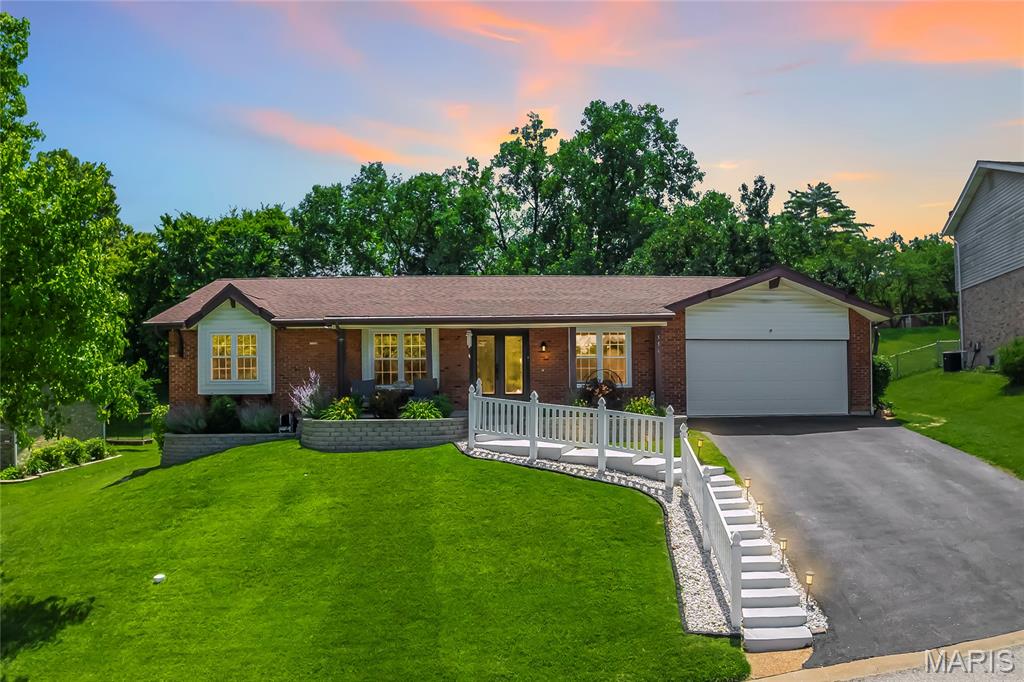 Some homes just live well, and this one is a perfect example. Tucked on a quiet cul-de-sac in the sought-after Danbury neighborhood, 556 Sprague Mill Court offers the kind of lifestyle that's hard to replicate: top-rated Rockwood/Marquette schools, a neighborhood pool just steps away, and easy access to Ballwin Golf Course and Event Center, Vlasis Park, and all the dining and conveniences Manchester Road has to offer.

The backyard sets the tone. A large concrete patio with a curved sectional, fire table, and hot tub creates an outdoor living space that feels more like a resort than a suburb. The fully fenced yard with mature trees offers privacy and room to play, and the built-in outdoor kitchen with a gas grill and bar seating makes entertaining effortless from the moment the weather turns. The roof was replaced in 2025, all main level windows were replaced with triple-pane glass in 2024, and the gutters have leaf filter screens, so the big-ticket items are already done.

Inside, the sellers completed an extensive main floor remodel that touched nearly everything: new laminate flooring throughout the main level, updated electrical including a 200-amp panel, all new interior doors, fresh paint on every wall and ceiling, and a redesigned fireplace with stone surround and insert. The kitchen was further elevated in 2025 with quartzite countertops, a new backsplash, a farmhouse sink, and updated appliances. The open living area features a fireplace, recessed lighting, and sliding doors that pour in natural light and connect directly to the patio. A formal dining room with crown molding and a statement chandelier rounds out the main living spaces nicely.

The primary suite is spacious and well-appointed, complete with a remodeled bath featuring onyx shower panels, a 60-inch vanity, and tile flooring. The additional bedrooms are well-sized and flexible, and a dedicated home office with crown molding, recessed lighting, and hardwood floors works just as well as a fourth bedroom. The updated hall bath features a marble-top vanity and tiled tub surround.

The finished lower level adds significant living space, with a long open rec room, recessed lighting, and room for whatever you need it to be.

Out front, the tiered retaining walls and flower beds were replaced in 2023, giving the home a polished, low-maintenance curb appeal that matches the care put into everything inside.