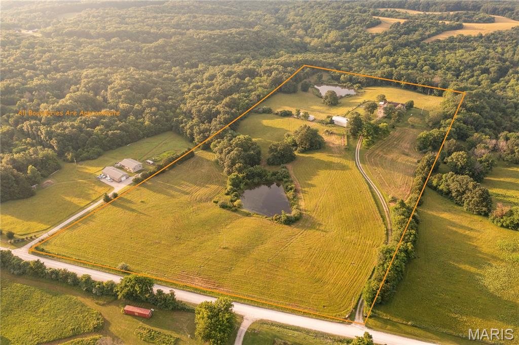 Welcome to 1010 Tick Ridge, a beautiful 20±-acre country property offering the perfect blend of comfortable living, recreation, and agricultural opportunities. Tucked back from the road for added privacy, this well-maintained farm features breathtaking views of the surrounding countryside and a peaceful setting that's hard to find.

Built in 2003, the 3-bedroom, 2.5-bath brick home offers 1,874 square feet of living space plus a finished basement, providing plenty of room for family and guests. An attached 2-car garage adds convenience, while the home's inviting layout makes it ideal for both everyday living and entertaining.

The land is comprised primarily of productive pasture and hay ground and is mostly fenced, making it well-suited for livestock, horses, or a hobby farm. Improvements include a large barn with a lean-to and a separate horse shed, providing ample storage and functionality for a variety of agricultural uses.

Outdoor enthusiasts will appreciate the property's two stocked ponds and abundant wildlife. With no hunting pressure since 2003, the farm has become a sanctuary for deer and turkey while maintaining its peaceful atmosphere.