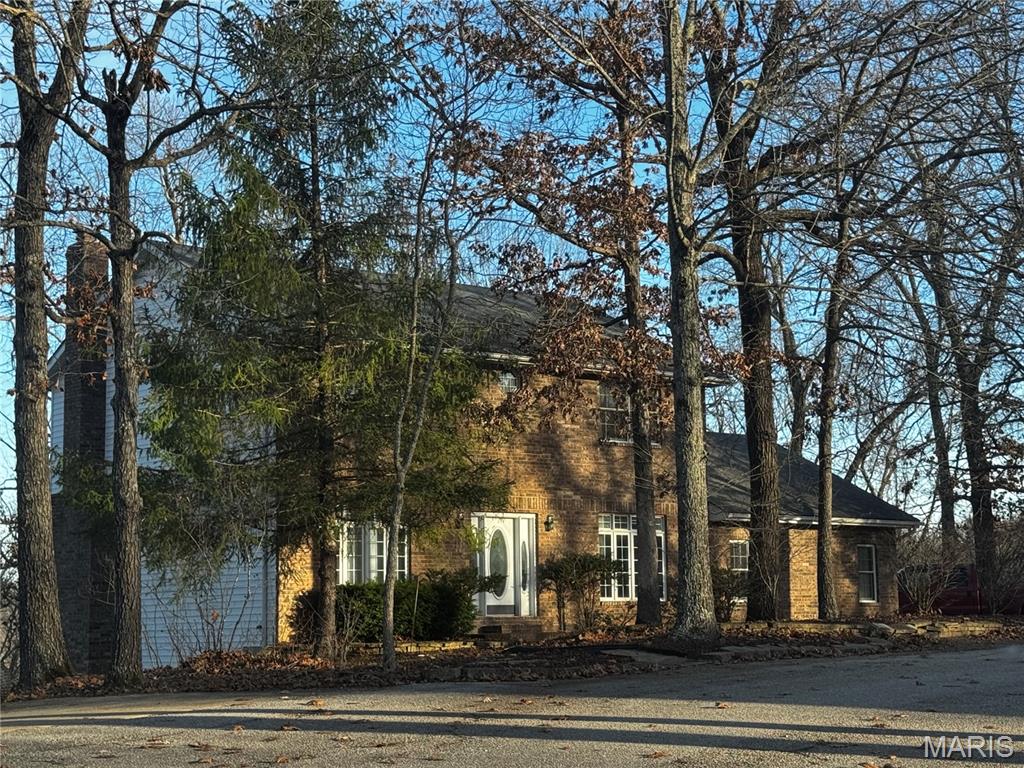 Ideal family home located on a quiet cul-de-sac in a fantastic neighborhood-located less then 10 minutes from Fort Leonard Wood. 4 Large bedrooms and 3 1/2 baths makes this roomy home perfect for any family. The Primary bedroom is on the second floor with 2 walk-in closets and double vanity en suite with beautiful light filtering in from each end of the house... lovely French doors on main level between parlor and living room provide easy expansion for family/social gatherings or closing off for separate cozy multi-use spaces. Special features include a unique double -sided glass door custom kitchen cabinet as well as a beautiful custom multi-shelf built -in hallway display cabinet. Stainless appliances in great condition round out the spacious kitchen. Finished walk out basement features a great room with a warm fireplace , extra bedroom, office space or game room and hook-ups for extra refrigerator /microwave. Ultra convenient workshop room within secure garage for the handyman or hobbyist. This home has Great Brick facade and built with quality materials that make this home stand out from others. A gardeners delight with slopes full of custom-planted lilies of the valley along with lily of the Nile, rose bushes , roses of Sharon, lilacs peonies and more.....Watch the sun rises with your morning coffee from the beautiful forest-bordered & private 2nd story outdoor deck that doubles for great family gatherings.