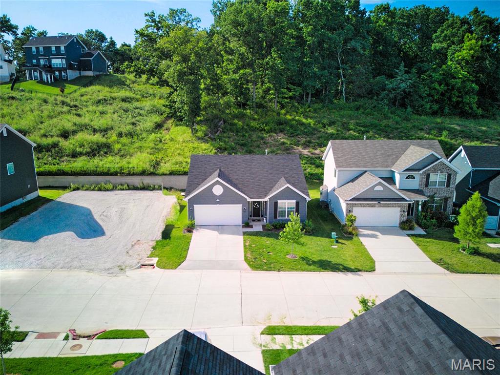Welcome to this beautiful Fenton ranch home, built in 2024 and located in a great community! You'll love the neighborhood amenities: a dog park, pickleball court, and ponds with scenic walking trails. Lovely curb appeal and a covered porch welcome you inside. The foyer leads to the open layout of the main living space, perfect for hosting gatherings or relaxing with family. Featuring vaulted ceilings and wide-plank laminate flooring, the great room is open to the showstopper kitchen and breakfast room with a bay window. Thoughtful upgrades include quartz counters, 42" white cabinets, stainless steel appliances, and a large center island with a breakfast bar. The primary suite has a walk-in closet and bathroom with step-in shower and large vanity. Two more spacious bedrooms, another full bathroom, and a convenient laundry room complete the space. You'll have plenty of storage space in the unfinished basement, with bathroom rough-ins and an egress window for your future finishes. You'll have a convenient EV charging outlet in the garage. Enjoy summer on the private, covered patio overlooking the backyard and woods beyond. Just moments from George Guffey Elementary, with quick access to 141 and 30, I-55, I-44, and I-270, and all of the restaurants and shopping at Gravois Bluffs, this home is one you won't want to miss!