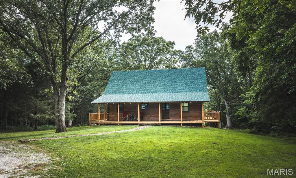 Just minutes from town and accessible off a paved highway, this 87 acre property offers convenience and seclusion. It features over 1/4 mile of Hog Creek, providing a peaceful backdrop for activities like fishing, swimming, or enjoying the beauty of nature. The custom-built cedar lodge spans over 2,100 sq ft and showcases true craftsmanship. With pine floors, custom beams, and black iron railings, every detail of this home has been thoughtfully designed. The spacious layout includes 3 bedrooms and 2 full baths, offering both relaxation and ample space for entertaining. Whether you're relaxing on the expansive front or back deck, the home offers the perfect spots to unwind while soaking in the natural surroundings. Tucked away in a grove of towering cedars, the lodge provides privacy while still being conveniently close to town and all necessary amenities. The property boasts a 40x60-foot all-steel shop building, equipped with electricity and double 12-foot lean-tos, plus a bathroom.