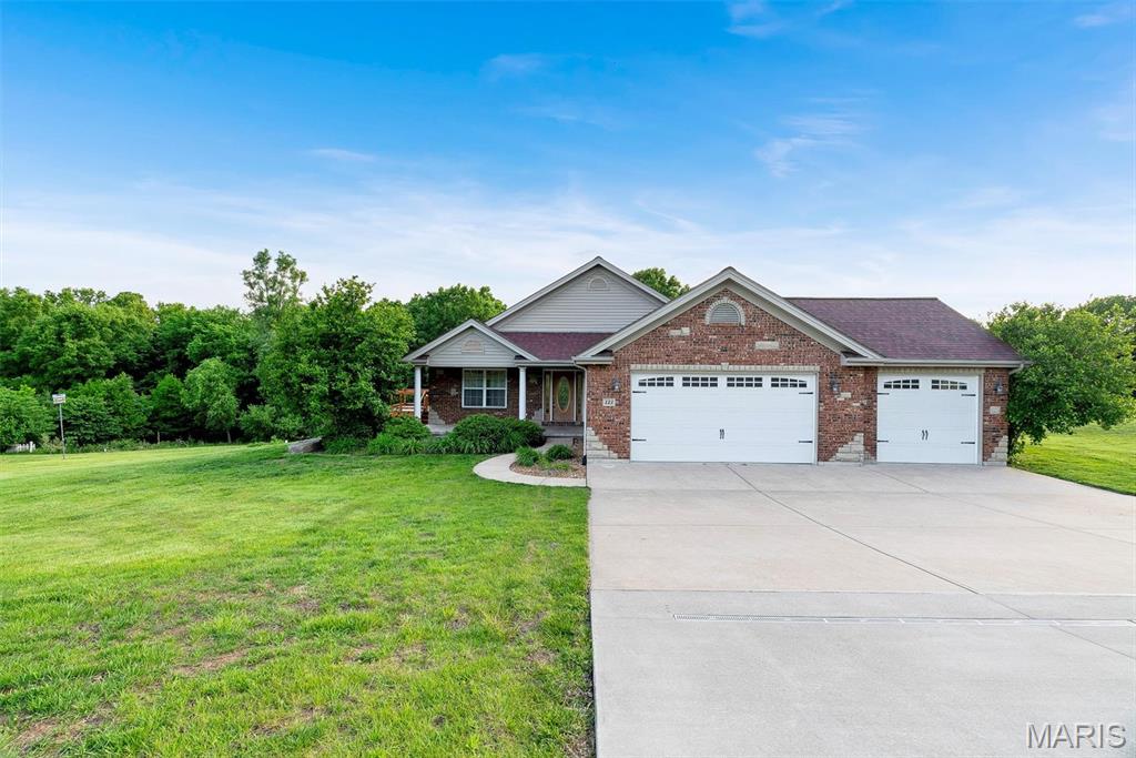 Spacious 2,015 sq ft ranch on 3 acres with a 3-car garage, offering the perfect blend of comfort, space, and opportunity. This well-maintained home features hardwood floors, a bright living room with large windows and a cozy wood-burning fireplace, and a functional kitchen with solid surface countertops and classic oak cabinetry. Two generously sized bedrooms share a full hall bath, while the large primary suite includes a walk-in closet and a private bath with double vanity, jetted tub, and walk-in shower. The walkout basement is unfinished with a rough-in, providing an excellent opportunity to add additional living space, bedroom, or bath. Outside, enjoy the expansive yard and peaceful views from two decks. Tucked back in a quaint country neighborhood, this property offers privacy and room to spread out. Being sold as-is, the home needs minor cosmetic updates but has solid bones and incredible potential for its next owner.