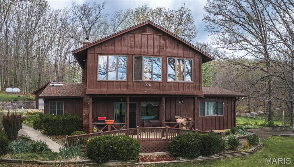 Tucked away east of Salem and surrounded by the beauty of the Mark Twain National Forest, this stunning 80-acre property that offers the perfect blend of privacy, comfort, and outdoor recreation.
The home features 4 bedrooms and 2.5 baths, including a versatile main-level mother-in-law suite that could easily serve as your primary suite with the other 3 bedrooms on the upper level. A recently remodeled kitchen, rich hardwood floors, and a warm, inviting living room with a wood-burning fireplace create a cozy, welcoming atmosphere. The enclosed sunroom provides the perfect spot to relax and take in the peaceful surroundings year-round.
Outside, the property continues to impress with a detached garage and an expansive 142’x70’ steel pole barn, formerly used as an indoor riding arena, offering endless possibilities for hobbies, storage, equipment, or livestock. A backup generator adds peace of mind, ensuring comfort in any season. Looking around, you see a landscaper's dream with tiered flower beds all around the home, an old school well house, a cellar, and new steel fencing. 
The land itself is a true highlight, featuring mostly wooded acreage with a serene creek winding through it, visible from multiple points in the home and on the nice deck, complemented by beautiful pine groves and mature oak trees. Open areas that are perfect for horses, food plots, adding additional buildings, or other animals. Abundant wildlife makes for excellent whitetail deer and turkey hunting, while the nearby Meramec River offers even more opportunities for outdoor adventure just minutes away.
An opportunity to own a secluded, peaceful property in an unbeatable setting, this is country living at its finest.