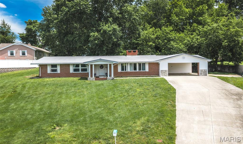Tucked at the back of a quiet cul-de-sac, 32 Sydney Court blends mid-century modern charm with comfortable one-level living in the heart of Rolla. This 3-bedroom, 2-bath ranch offers 2,025 sq ft with an open, easy-flowing layout, beamed ceilings, built-in bookcases, abundant storage, and a beautiful see-through masonry fireplace connecting the living and dining spaces. Updated kitchen cabinets with a conveniently located laundry room. The newly remodeled shower stall in primary bathroom with new fixtures adds a fresh touch, while the large back patio, front porch, partial wood backyard updated metal roof, and 2-car carport add everyday function. Set on a .51-acre lot, this home is full of character, space, and investment opportunity.