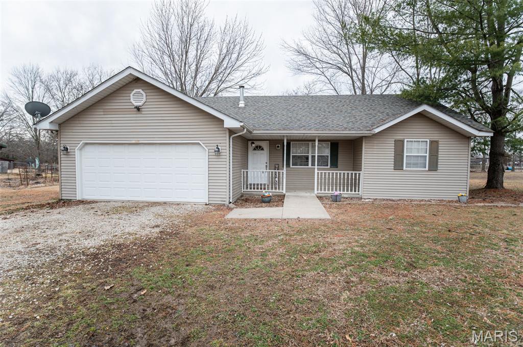 Upon entering this 3 bed/2 full bath home, you will notice the covered front porch, vaulted ceilings, and open layout of Living Room/dining room that offers sliding glass doors to the back deck and fully fenced in spacious back yard. The kitchen offers plenty of cabinets and counter space, and an open serving bar that extends into the dining room, perfect for serving your family.  The primary bedroom offers a full bath and his and her closets. The two other bedrooms have ample closet space and are a great size. This home offers a lot of natural light, a separate laundry room and an oversized attached garage. Directly behind this home is the city park offering a nice view of the city lake and is in a great neighborhood! This home is just waiting for you to make it your own! Schedule your showing today and see what all this home has to offer!