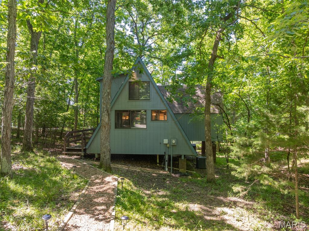 Nestled on a wooded .87 acre lot along the shores of Lake Audubon, this thoroughly updated chalet sits on the eastern side of Innsbrook — minutes from the main gate, the clubhouse, and the golf course — yet completely sheltered from the world the moment you step onto the property and located on Lake Audubon. The improvements speak for themselves. In 2023, the Chalet was updated top to bottom: new countertops, new appliances, new bathroom vanity, updated light fixtures and ceiling fans, new electrical outlets, fresh interior paint throughout, and a graveled and graded driveway. They also installed a private beach area at the water's edge — an amenity that creates direct, easy lake access right on your own lot. In 2024, a hot tub and outdoor sauna were added, transforming the outdoor space into a four-season retreat. A new water heater and dock stair replacement were completed in 2025. Inside, a wood-fired stove anchors the living area with warmth and character, while the loft bedroom and flexible sleeping arrangements comfortably accommodate up to eight guests. The first-floor bathroom features a shower with a waterfall showerhead. A flat, easy walk leads from the chalet to the dock and zero-entry rock beach, where paddle boats and kayaks are included with the sale. Currently operating as a self-managed STR with a 4.92-star rating across 25 Airbnb reviews and consistent recognition for location, outdoor spaces, and amenities, this property has built a genuine guest following. Turnkey. Waterfront. Proven. Don't let this one wait.