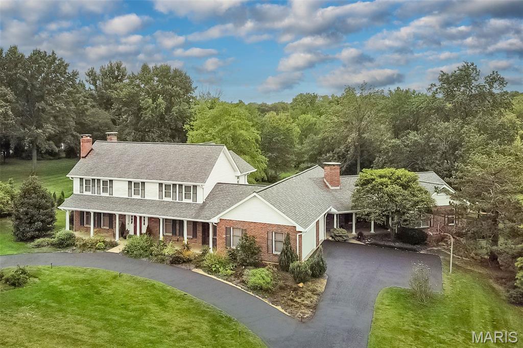 Set on a picturesque 1+ acre lot in desirable Huntington Farm, this elegant Colonial offers over 7,700 sq ft of finished living space designed for both grand entertaining and comfortable everyday living. A circular drive welcomes guests with timeless curb appeal and landscaping.
The main level features beautifully proportioned formal living and dining rooms, rich millwork, crown molding, and multiple fireplaces. The custom, updated kitchen is a chef’s dream with high-end appliances, granite countertops, expansive center island, abundant cabinetry, and a large pantry with a built in refrigerator, custom cabinets and additional counterspace perfect for large scale holidays and parties. Natural light spills into the breakfast room which overlooks a yard brimming with perennials—as does the 2 story greatroom and adjoining light-filled sunroom with vaulted ceiling and walls of windows provides year-round enjoyment.
A standout feature is the private in-law suite with its own full kitchen, living area, bedroom, bath, and separate entrance, offering exceptional flexibility for multi-generational living or extended guests. 
Upstairs, the home boasts generously sized bedrooms including a serene primary suite with large walk-in closets and spa-like bath. The finished walk-out lower level adds recreation space, with a custom built playroom, den with fireplace, and a game room as well as a full bath convenient to the pool. This space can provide for a home office, hobby room or exercise.
Outdoor living is equally impressive with multiple patios, pergola with outdoor fireplace,a beautiful pool, play yard, and lush grounds perfect for gatherings or quiet relaxation. Additional amenities include a 3-car side-entry garage, zoned HVAC, inground sprinklers, hardwood floors, custom built-ins, and extensive storage throughout.
Ideally located in the Parkway School District and close to shopping, dining, major hospitals, and easy highway access, this remarkable home offers space, privacy, and versatility in one of Town & Country’s most sought-after neighborhoods.