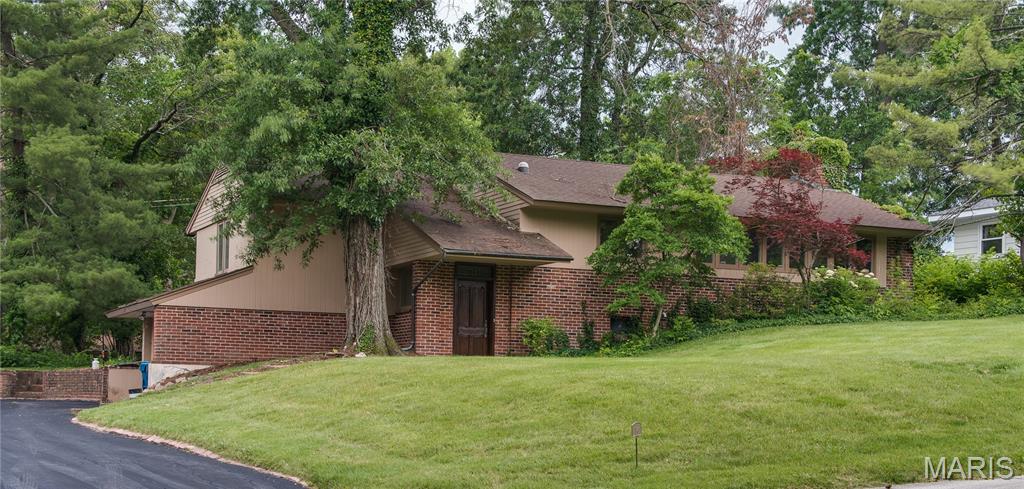 Mid-century modern in Ladue school district. This multi-level home has 3 bedrooms and 2 full baths. The front and back of the home each feature rows of windows that let in tons of natural light. The living room is further brightened by 2 skylights, a cathedral ceiling with valance lighting and LED cans. There is a wall of built-in bookcases and hardwood flooring. Walkout from here to the paver brick patio and expansive natural yard. There is a floor to ceiling exposed brick fireplace adorns entire wall spilling into the dining area. Here you’ll find a bank of windows and blown glass pendant lighting again with hardwood flooring, adjacent is the galley-style kitchen in white featuring plenty of counterspace with European style cabinetry solid surface countertops and wood floors and tons of natural light. Completing the upper level are 2 good size bedrooms with wood flooring and a hall bath with classic terracotta floor tile. Downstairs extends the living area with a proper 3rd bedroom due to walk out. fully remodeled bath with large format tile shower and a large recreation room with second fire place with the full wall brick motif and recently replaced plank flooring.  Don’t let the lower-level fool you plenty of natural light yet a cozy place to relax. Casement windows though most for the house. 2 car oversize lower entry garage. Separate Storage shed. Located off Lindbergh in a quiet Tealwood subdivision this home is ready to go. Special access security gate to Warson road via electronic gate opening make everything so much more convenient Expansive lot with mature trees plenty of shade and privacy. Close to new Olia development for future entertainment and shopping options as well as the up and coming 39 North biosciences development.  East access to Clayton, Airport, Creve Coeur Olivette and University City shopping districts and restaurant districts.
