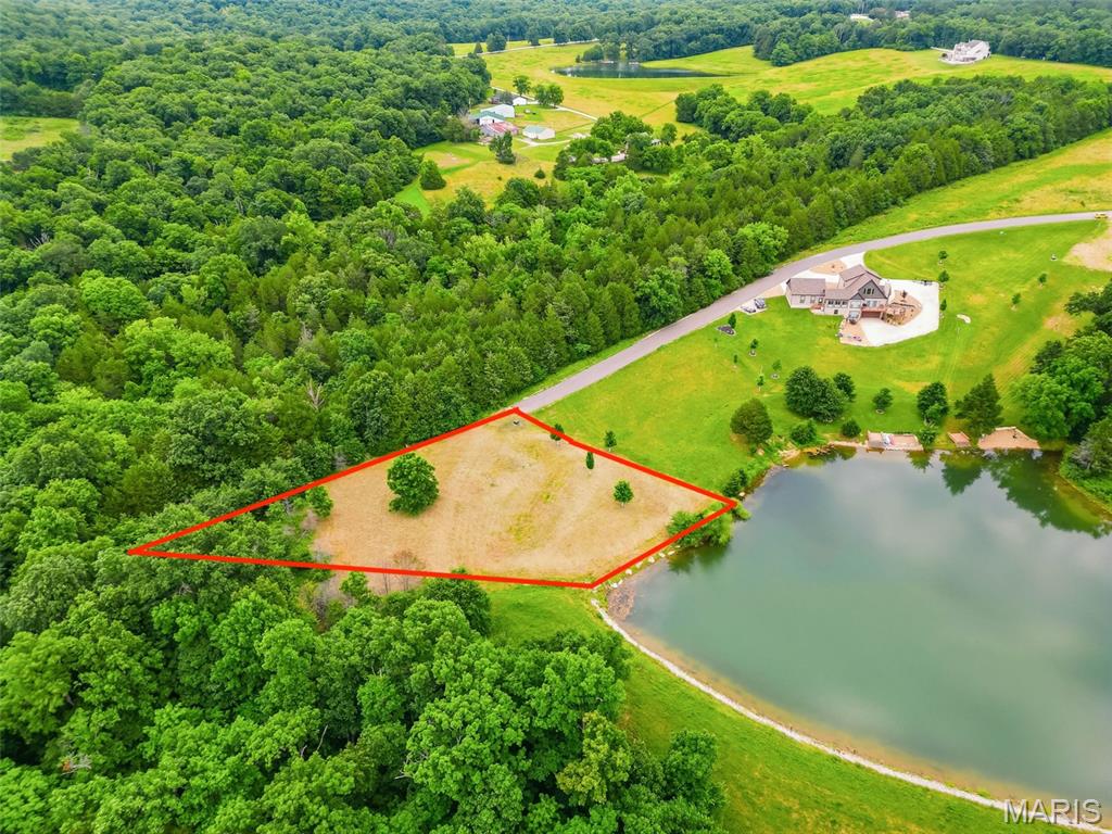 Discover the perfect setting for your custom cottage on this beautiful 1.01-acre lakefront lot in Innsbrook's desirable Tyrolean area. Featuring nearly 100 feet of shoreline, this picturesque homesite offers the ideal blend of water access, privacy, and natural beauty. The generous lot size allows your cottage to be tucked back among the trees, creating a peaceful wooded setting while still enjoying lake views and easy access to the water.
A rare opportunity exists to purchase the adjoining lot at 2694 Klor Lane, giving you nearly two acres and a substantial portion of the shoreline along the right side of the lake. With a minimum build requirement of just 1,200 square feet and no required timeline to build, you can create your dream retreat at your own pace. Conveniently located near Innsbrook's pools, hiking trails, pickleball courts, fitness center, golf course, and Amphitheatre, this exceptional property offers the best of resort living in one of Missouri's premier gated communities.