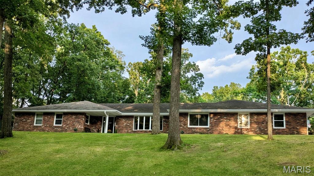 Tucked away on 2.14 wooded acres, this extensively updated home offers a setting that's hard to find. It feels like you're out in the country while still being just minutes from shopping, restaurants, and schools. The mature trees and wooded surroundings provide a level of privacy that's uncommon for an in town property.
With 4 bedrooms, 3 full bathrooms, 2 half bathrooms, and laundry hookups on both the main level and in the basement, there's plenty of room for family, guests, and entertaining. The main level features a spacious family room, an informal sitting room, and a large formal dining room. Brazilian teak flooring, custom Beussink cabinetry, granite countertops, and quality finishes can be found throughout.

Just off the family room is a finished four season sunroom complete with a mini split, wet bar, sink, mini refrigerator, hood fan, and gas hookup for grilling. Step outside to the composite deck overlooking the wooded backyard or relax on the new paver patio with a fire pit. The landscaping has been professionally redesigned by Bloomfield Landscaping and completes the outdoor living space.

The primary suite includes a beautifully remodeled bathroom with a tiled glass shower, freestanding soaking tub, double vanity with granite countertops, and custom Beussink cabinetry.

The walkout basement adds even more living space with LVT flooring, a projector for movie nights, built in shelving, a fun climbing wall nook for the kids, a kitchenette with sink, cabinetry, and pantry, abundant storage, and a second set of laundry hookups.

Recent improvements also include new windows, new front and rear entry doors, an oversized sliding glass door, remodeled bathrooms including a main level laundry room/bathroom with dog wash, a heated and cooled garage with a floor drain, an expanded driveway with room for an RV, raised garden beds, retaining walls, and extensive landscaping.

Homes like this don't come on the market very often. If you've been looking for privacy, quality updates, and a home that's truly move-in ready without giving up the convenience of being in town, this is one you'll want to see. Please see the listing supplements for a complete list of updates and improvements made by the current owners.