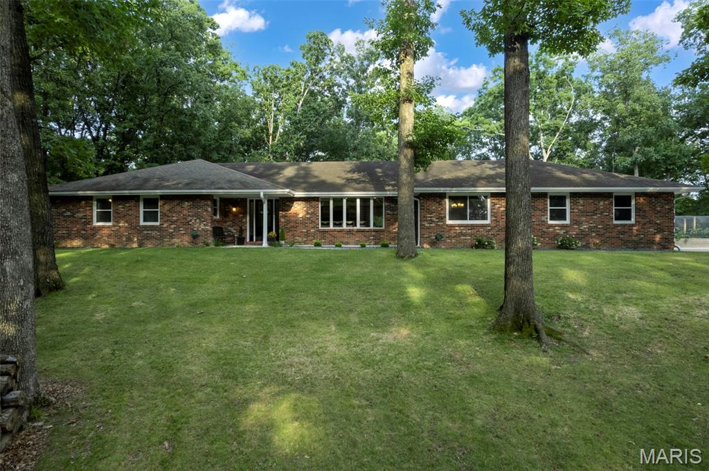 Tucked away on 2.14 wooded acres, this extensively updated home offers a setting that's hard to find. It feels like you're out in the country while still being just minutes from shopping, restaurants, and schools. The mature trees and wooded surroundings provide a level of privacy that's uncommon for an in town property.
With 4 bedrooms, 3 full bathrooms, 2 half bathrooms, and laundry hookups on both the main level and in the basement, there's plenty of room for family, guests, and entertaining. The main level features a spacious family room, an informal sitting room, and a large formal dining room. Brazilian teak flooring, custom Beussink cabinetry, granite countertops, and quality finishes can be found throughout.

Just off the family room is a finished four season sunroom complete with a mini split, wet bar, sink, mini refrigerator, hood fan, and gas hookup for grilling. Step outside to the composite deck overlooking the wooded backyard or relax on the new paver patio with a fire pit. The landscaping has been professionally redesigned by Bloomfield Landscaping and completes the outdoor living space.

The primary suite includes a beautifully remodeled bathroom with a tiled glass shower, freestanding soaking tub, double vanity with granite countertops, and custom Beussink cabinetry.

The walkout basement adds even more living space with LVT flooring, a projector for movie nights, built in shelving, a fun climbing wall nook for the kids, a kitchenette with sink, cabinetry, and pantry, abundant storage, and a second set of laundry hookups.

Recent improvements also include new windows, new front and rear entry doors, an oversized sliding glass door, remodeled bathrooms including a main level laundry room/bathroom, a heated and cooled garage with a floor drain, an expanded driveway with room for an RV, raised garden beds, retaining walls, and extensive landscaping.

Homes like this don't come on the market very often. If you've been looking for privacy, quality updates, and a home that's truly move-in ready without giving up the convenience of being in town, this is one you'll want to see. Please see the listing supplements for a complete list of updates and improvements made by the current owners.