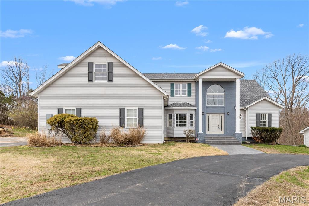 OPEN HOUSE: Saturday July 11th 1-2:30 & Sunday July 12th 11-1:00! Welcome home to this beautifully renovated 6 bedroom, 6 bathroom retreat nestled within nearly 3 acres of mature, wooded privacy. From the moment you arrive, the warm and welcoming open layout draws you in with soaring vaulted ceilings with exposed wood beams, rich warm-toned trim, and slate-toned tile floors flowing throughout. Two fireplaces anchor the living spaces, creating that cozy, come-as-you-are feeling that makes this home truly special. The lot features about 600' of frontage to the pond, offering beautiful view during your morning coffee to wrapping up the day watching the sunset over the water. The state-of-the-art kitchen is a showstopper, featuring dark granite countertops, a herringbone tile backsplash, stainless steel appliances, a large island with seating, and a charming breakfast nook giving you everything you need to cook, gather, and entertain. Oversized bedrooms offer generous space and comfort throughout, while the stunning primary suite serves as its own private escape with vaulted ceilings, French doors to the rear deck, a marble-look soaking tub, and a frameless glass shower. First floor laundry and 2 new HVAC systems and new furnace keep everyday living effortless. Head downstairs to the fully finished walkout basement, complete with a full wet bar, rec room, family room, a private bedroom and full bath. All opening directly to your finished backyard and sparkling inground pool. The main floor wraps to a full walk-around deck across the entire rear of the home, where wooded views and fresh air make every morning feel like a getaway. Fullfilling the car lovers dream, the detach garage is built to match the home, featuring a built in car lift, skylights, gables, a wood burning heater, eletric, and a concrete foundation. Accommodating up to 7 cars, the opportunities are endless with this rare find just steps away from the house.  This home beautifully blends timeless luxury with a warm countryside appeal that simply cannot be replicated. And HOA fee is voluntary for road dues.