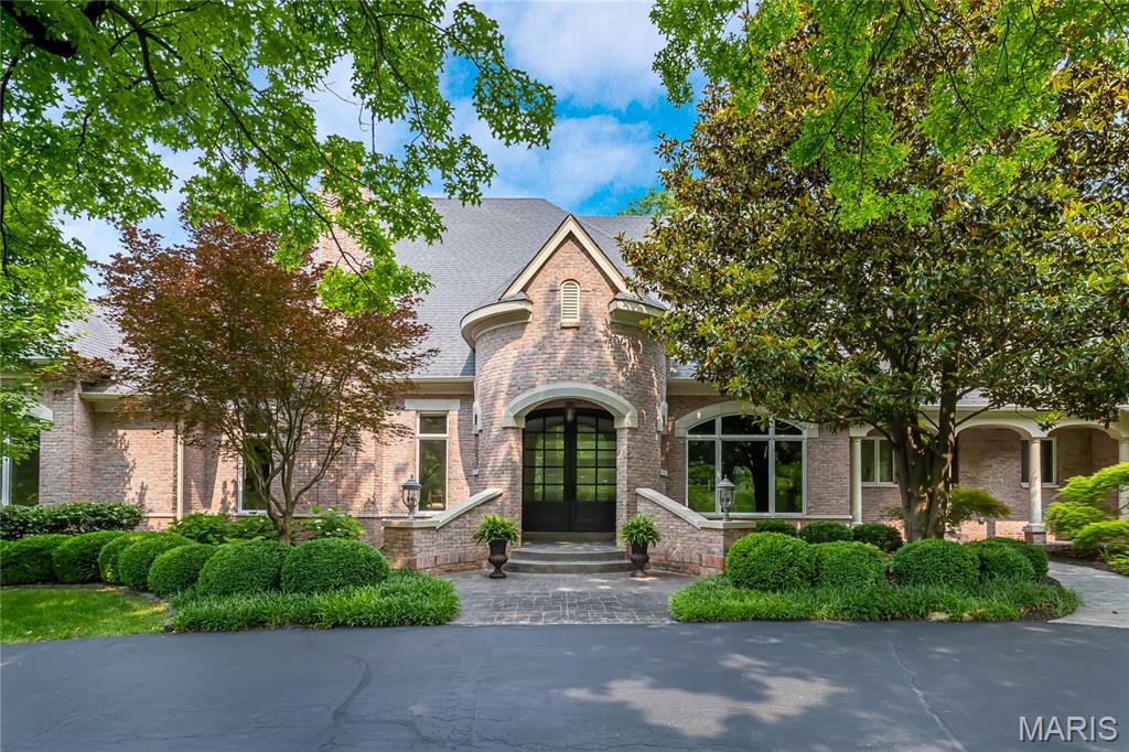 Nestled on an exclusive gated lane, this exceptional DeShetler-built estate has been extensively reimagined to meet the highest standards of todays lifestyle. Set on over an acre of meticulously landscaped grounds, the home offers more than 8,900 sq ft of refined living space. A grand marble foyer opens to wide-plank French oak flooring, soaring 12-foot ceilings, intricate moldings, and elegant arched passageways. The richly appointed study features bespoke paneling and built-ins, while the formal dining room is perfect for sophisticated entertaining. The expansive great room impresses with a beamed cathedral ceiling, fireplace, and Palladian windows. Designed by Marc-Christian, the kitchen includes Wolf and Sub-Zero appliances, a sculptural marble hood, double-stacked countertops, Visual Comfort lighting, a butler’s pantry, and wet bar. The hearth room and sunlit breakfast room offer cozy gathering spaces. The main-level primary suite boasts a coffered ceiling, marble fireplace, couture closet with laundry, and spa-inspired marble bath with freestanding tub. Two additional en-suites complete the main level, with a fourth bedroom and large bonus room upstairs. The walk-out lower level offers a full bar, game room, fitness studio, media room, fifth bedroom, and full bath. Outdoors, enjoy a free-form saltwater pool, outdoor kitchen, and terrace. An over-sized four-car garage completes this premier estate in a prestigious gated enclave.