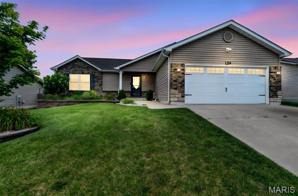 Welcome home to comfort, space, and effortless living in this beautifully maintained ranch located in the highly sought-after Wentzville School District. Thoughtfully designed with a desirable split-bedroom floor plan, this move-in ready home offers approximately 2,500 square feet of finished living space with the perfect balance of open gathering areas and private retreats. A soaring vaulted ceiling highlights the spacious great room, which flows seamlessly into the kitchen and breakfast area, creating an inviting space for everyday living and entertaining. The kitchen features rich 42" espresso cabinetry, granite countertops, stainless steel appliances, abundant workspace, and ceramic tile flooring. Even better, the refrigerator, washer, and dryer are all included. Fresh interior paint and brand-new carpet throughout the main level give the home a crisp, updated feel. The conveniently located main-floor laundry room offers additional cabinetry, shelving, and a storage closet just inside the garage entrance. Privately situated on one side of the home, the spacious owner's suite provides a peaceful retreat complete with two oversized walk-in closets, dual adult-height vanities, and a walk-in shower with built-in seat. Two additional bedrooms and a full bath are thoughtfully located on the opposite side of the home, making the layout ideal for guests, children, or a home office. The finished lower level significantly expands the living space with an expansive recreation room featuring luxury vinyl plank flooring, a beautifully updated full bath, and a rough-in for a future wet bar or beverage center, creating endless possibilities for entertaining, game nights, or multi-generational living. Step outside through the breakfast room sliding door to an oversized patio overlooking a beautifully landscaped, level backyard that backs to common ground, offering additional privacy and a peaceful setting to enjoy morning coffee or evening gatherings. With approximately 2,500 square feet of finished living space, fresh updates, generous storage, an outstanding floor plan, and a prime location in the award-winning Wentzville School District, this home offers exceptional value and is truly move-in ready.
