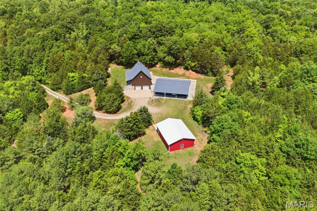 41-Acre Sustainable PRIVATE Paradise: Dual Residences, 3-Acre Pond & Massive Shop!
Don’t miss out on this 41.07+/- acre piece of paradise! This unique estate features a dual-residence layout perfect for multi-generational living, a premier hunting retreat, or a high-yield Airbnb investment. The primary residence is a custom 2000 sqft Earth Home built in 2019, offering unmatched energy efficiency and storm peace of mind. Connected via an above-ground concrete walkway is a secondary structure featuring a full basement/tuck under garage with stairs leading to the roughed-in 1,650 sq. ft. cabin above. The cabin is a blank canvas featuring stunning cedar walls and vaulted ceilings, a 1,200 sq. ft. main level (2BR/2BA), and a 450 sq. ft. upper loft—just waiting for your finishing touches! The park-like grounds are a dream for outdoorsmen, featuring a manicured trail system leading to a 3+/- acre stocked pond. The pond site is fully equipped for camping with its own 100-amp service, camper hookups, and private well. Infrastructure is top-tier, including a full basement under the second structure with a two-car tuck-under garage and additional storage, plus a separate 30x40 detached garage that is fully insulated with concrete floors and electric. Ultimate reliability is provided by a 36KW Generac whole-home generator and a solar-powered security gate. Whether you want to hunt, fish, or live off the grid in luxury, the opportunities here are endless!