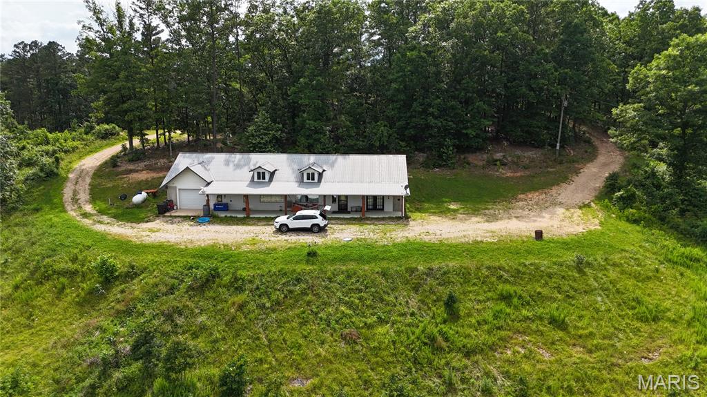Located between Salem and Eminence is this Ozark hilltop beauty on 26 peaceful and secluded acres just minutes from Echo Bluff State Park, Sinking Creek, Current River State Park, Devils Well and Alley Springs, just to name a few. This home faces east and is nestled into the side of an Ozark hilltop, offering breathtaking views and picture-perfect sunrises. This beautiful retreat features a large open floor plan with 3 large bedrooms, 3 bathrooms, a large living room, and an open-concept kitchen/dining area with skylights for natural light throughout. Recent updates include new plumbing, new luxury waterproof vinyl flooring, a new heating and air conditioning system, a new water heater (two hot water heaters total), and the primary bedroom bath boasts a new tile walk-in shower. Ample wildlife including wild horses are often seen roaming the forests. Oh, sorry, I forgot to tell you about the bears. Don't delay. Call today to see this amazing property right in the heart of our beautiful Missouri Ozarks.