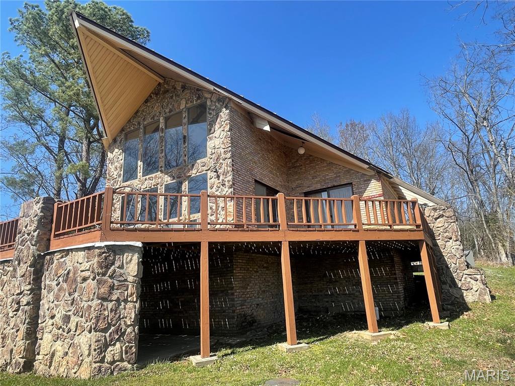 MILLION DOLLAR VIEW!!!!!!!!!!  Probably the property with the prettiest view of Current River!!!!  Upon entering the secured gated area this river home is at the end of the lane.  Home features A frame brick and rock exterior with metal roof and soffit. Decking all around where you can relax and listen to the water flowing.  Home has 2 bedrooms, and extra room that could be used as a 3rd bedroom, 2 bathrooms, open floor plan kitchen, dining room, and living room.  Living room has huge vaulted ceilings and floor to ceilings windows that display a picture perfect view of the river.  Upstairs is a loft that could be used as a family room or office with beautiful view of the river. There is a concrete storm shelter with plumbing that could be finished out for a bath.  Entrance can be from outside or inside from living room. There is a 2 car garage and all appliances stay with the home and there are 2 heat and air units.  With gated entry, approximately 150 feet of river frontage, community boat launch, community well, priceless view up and down river with gravel beach, this is a must see if you are looking for a great neighborhood of people to enjoy this life.  River season is upon us so call me asap before this beauty is gone.