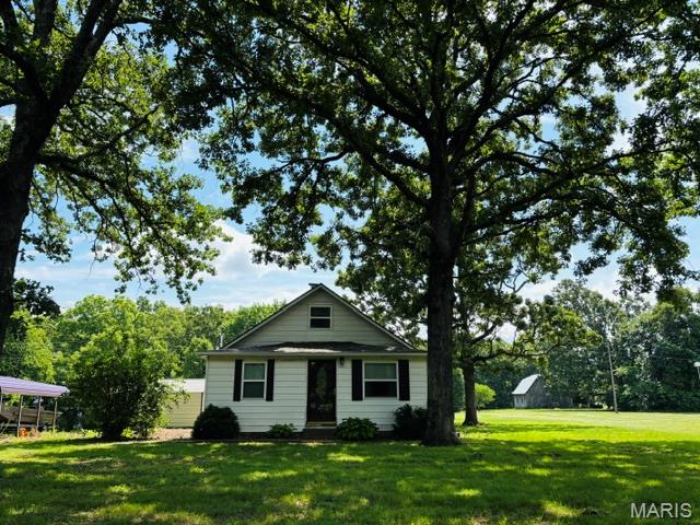 Escape to the peace and privacy of the countryside with this charming 1935 farmhouse nestled on 9 picturesque acres. Perfect for animal lovers and anyone dreaming of a homestead lifestyle, this property offers plenty of room for horses, goats, chickens, pets, and more to roam freely. The chicken coops stay, making it easy to start your hobby farm right away! The property features a spacious barn complete with electricity, ideal for livestock, equipment storage, workshops, or future projects. Two covered carports provide convenient parking and protection for your vehicles and farm equipment. Nature lovers will fall in love with the land itself, filled with mature fruit trees, persimmon trees, and an abundance of wild blackberries that add beauty and charm throughout the seasons. Inside, the home is full of timeless character and original 1935 craftsmanship. From the beautiful arched entryways to the cozy, updated kitchen featuring soft-close cabinets and drawers, this home perfectly blends vintage charm with modern convenience. Upstairs, you’ll find additional rooms and ample storage space, offering flexibility for bedrooms, office space, hobbies, or guests. One of the true highlights of the home is the relaxing sun porch overlooking the back of the property — the perfect place to enjoy your morning coffee, unwind in the evenings, and take in the peaceful country views. If you’ve been searching for a country retreat with charm, acreage, and room for all your animals and outdoor dreams, this one is a must-see. Schedule your private showing today before this rare countryside gem is gone!