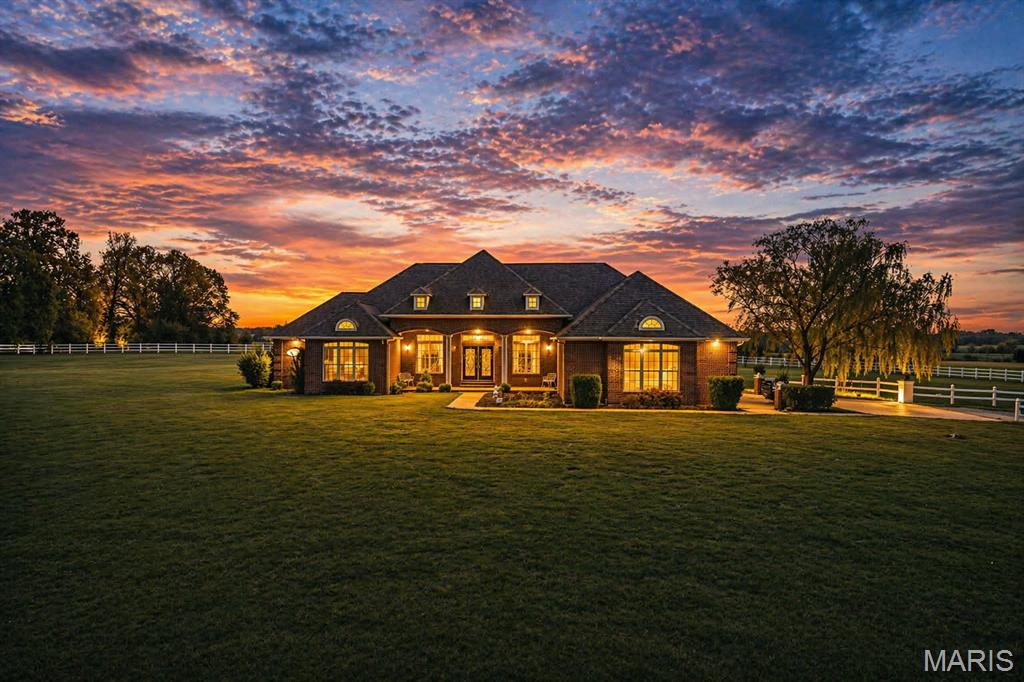 Set on 6 acres of lush, fully fenced countryside, this distinguished brick estate offers an exceptional blend of refined interior living and expansive outdoor opportunity. Thoughtfully designed with both elegance and functionality in mind, the home welcomes you with impressive 12-foot ceilings and beautifully appointed gathering spaces throughout. The formal dining room showcases marble flooring, creating a sophisticated setting ideal for hosting. At the heart of the home, the kitchen features a large center island, granite countertops, a Jenn-Aire stove, and a designated breakfast area with hardwood flooring, providing both everyday comfort and elevated entertaining space. Just beyond, the family room with an electric fireplace offers a warm and inviting retreat, while the formal double-sided sitting room adds timeless character and versatility. The spacious primary suite includes his and her closets and a luxurious ensuite bath complete with double vanity, jetted tub, separate shower, and an elegant crystal chandelier-a true private sanctuary. Additional highlights include an oversized laundry room with sink and extra storage, hardwired smoke detectors throughout the home, and enhances wall insulation for comfort and efficiency. Practical upgrades continue beneath the home with a 4-foot lighted crawlspace, and peace of mind comes with a brand new roof just recently installed within the last month. (June 2026) For an additional acreage, see MLS 26037917. A rare opportunity to own a refined country estate with acreage, privacy, and thoughtful upgrades throughout. Call us to schedule your showing today to see if this could be YOUR next home!