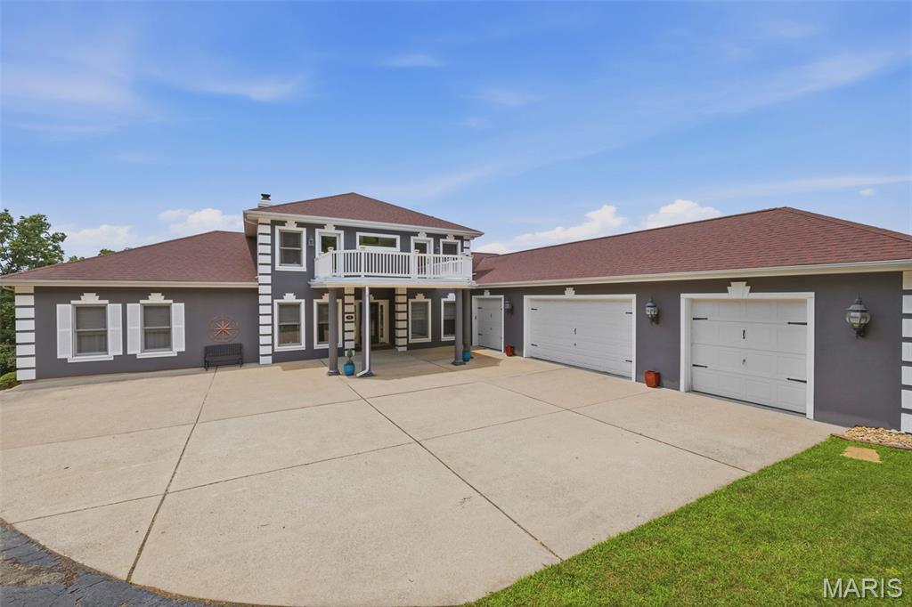 Nestled in the scenic, rolling hills of Wildwood, Missouri, this stunning estate offers the perfect blend of sophisticated design, high-end modern upgrades, and a private backyard oasis. From the moment you arrive, the pride of ownership shines through, highlighted by a freshly painted exterior completed just two years ago and newly replaced garage doors that add to the home's striking curb appeal.

Step inside to an entrance foyer, beautifully bookended by a formal dining room and an elegant sitting room. The main level flows effortlessly into a spacious living room featuring updated, durable luxury vinyl plank flooring that seamlessly combines style with low-maintenance living. Culinary enthusiasts will fall in love with the expansive kitchen, which offers abundant storage in custom cabinetry, a generous walk-in pantry, and a large central island perfect for meal prep and casual gathering. Nearby, the family room serves as the ultimate media hub, hosting a custom entertainment system with a television, soundbar, receiver, and sound system fully wired to deliver seamless audio throughout the main floor and straight out to the outdoor living spaces. Tucked away on this main level for ultimate convenience is the primary suite—a spacious, private sanctuary boasting two walk-in closets and a luxurious en suite bathroom.

The outdoor amenities are designed to embrace Wildwood’s beautiful natural backdrop and provide a true resort-style experience. Off the main level, a screened-in porch offers a peaceful retreat to unwind while taking in a truly breathtaking, show-stopping view of the property. Take the newly replaced deck stairs down to the spacious, securely fenced in backyard. A sparkling, recently tiled in-ground saltwater swimming pool also awaits outside, complete with a brand-new safety cover for ultimate peace of mind.

Upstairs, the home continues to impress with accommodations designed to give everyone their own private retreat, highlighted by the fact that every single bedroom features its own private balcony with elevated views of the property. Two of the upper-level bedrooms share a convenient Jack-and-Jill bathroom, while the third upstairs bedroom enjoys easy access to another beautifully appointed full bathroom.

The incredible living space continues in the fully finished walk-out basement, which doubles as an entertainment haven and guest quarters. Here, you will find a dedicated theater room for movie nights, a recreation space, a half bath, and two large, individual storage rooms to keep the home perfectly organized. A fifth bedroom and another full bathroom provide the perfect setup for guests, with a walk-out door leading directly to the backyard. To complete this exceptional property, the entire home is served by a premium Pura UV water filtration system and heavy-duty security doors have been installed at both the front and rear entrances for added peace of mind. Experience the pinnacle of eco-conscious luxury with a state-of-the-art, three-zoned geothermal heat pump system, an ultra-efficient technology that harnesses the earth’s constant underground temperature to provide whisper-quiet, customized climate control across three distinct areas of the home. Perfect for auto enthusiasts or those needing extra storage, the expansive four-car garage offers abundant, secure space for a multi-vehicle collection, a dedicated workshop, or recreational gear. This feature-packed Wildwood masterpiece is truly a rare find.