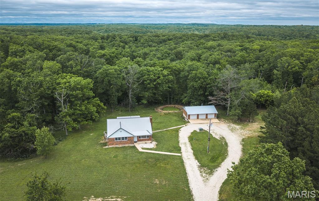 Completely renovated on the inside and packed with upgrades, this absolutely stunning property offers the perfect blend of privacy, beauty, and convenience! Situated on 47 amazing acres, this one-of-a-kind home features a gated entrance, incredible views, and endless opportunities for hunting, recreation, or simply enjoying peaceful country living. Inside, you’ll love the gorgeous solid wood kitchen cabinets, stainless steel appliances, quartz countertops, and the deck just off the kitchen/dining area — perfect for relaxing or entertaining. Major updates completed approximately 1 year ago include the HVAC system, water heater, appliances, water softener, garage doors and motors giving peace of mind for years to come. The primary bedroom is conveniently located on the main level and features a beautifully updated bathroom with a marble countertop and walk-in shower. Upstairs, you’ll find two oversized bedrooms connected by a guest bathroom, including one room with a fun secret room feature! The huge unfinished walk-out basement offers approximately 1,288 sq ft ready for your personal touch — whether you envision additional living space, a workshop, gym, or storage area. Outside, the detached 3-stall garage offers approximately 1,064 sq ft of additional space for vehicles, equipment, or hobbies. Located only about 15 minutes from the front gate of Fort Leonard Wood and approximately 7 minutes from Boiling Springs Campground, this property combines convenience with the tranquility of country living. With all of these upgrades and features, you do not want to miss out on this incredible property!