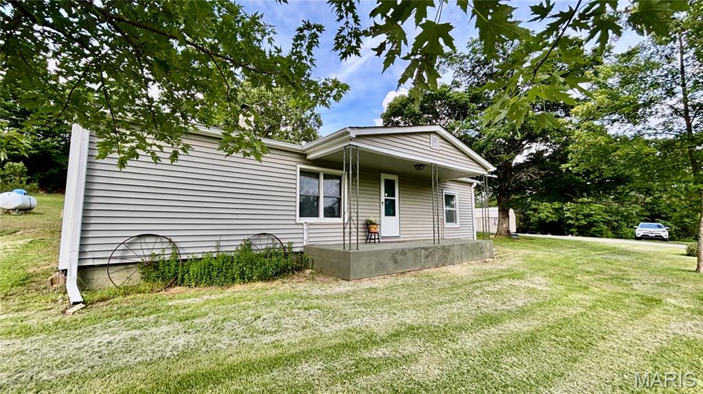Enjoy your 4.79 +/- Acres of Country Living at it Best!!! Just out of Town. This 3 Bedroom ,1 Bath with plenty of storage that is equipped with outbuildings. Your Screened in porch has a Porch Swing for you to take in the Beauty of the land and wildlife. The back porch has room for Storage or a great spot for the Freezer. The doggie door is installed and ready to keep your fur babies out of the weather!! The Outbuilding has electric to it, insulated, ready for your design to make your tiny home a dream come true. Or the kids might be ready to have their own space for a game room.  Come and enjoy the country living, No HOA!!! Nice Big Yard to play and roam the woods .