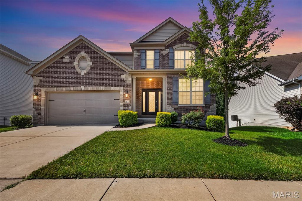 Fabulous two-story home in Dardenne Prairie, conveniently located just minutes from Highway 40/64 and the Page Extension. Outstanding curb appeal welcomes you with a gorgeous front door, striking brick and stone exterior, and a private wooded backdrop. The garage offers a Tesla Charger.

Inside, you'll find beautiful dark wood flooring, elegant rounded archways, and an abundance of natural light. The open-concept rear of the home is perfect for everyday living and entertaining. The gourmet kitchen is truly a chef's delight, featuring crisp white cabinetry, a large center island, stainless steel appliances including refrigerator, a spacious walk-in pantry, and an impressive five-burner gas range accented by custom stonework and tile that creates a stunning focal point.
The adjoining family room offers a cozy gas fireplace and picturesque views of the trees, while the formal dining room provides the perfect setting for holiday gatherings and special occasions.

Upstairs, you'll find the spacious primary suite, three additional bedrooms, a versatile loft, and the convenience of second-floor laundry, (washer and dryer included). The luxurious primary suite features a large walk-in closet and spa-like bath with dual vanities, a soaking tub, and a separate shower.

The walkout basement offers endless possibilities with a framed rear wall already in place, making it easy to finish and customize the space to fit your needs. In addition, there is a water softener and dual zone dampener AC and a Nest thermostat. Step outside to the deck and relax while enjoying the peaceful wooded views and exceptional privacy.
This beautiful home combines timeless style, thoughtful design, and an outstanding location—making it one you won't want to miss!