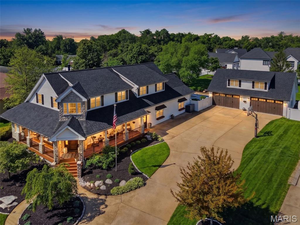An exceptional expression of luxury and craftsmanship, this custom, fully renovated residence offers remarkable scale, refined smart living, and a standout 4-car garage; all designed for those who appreciate quality and distinction. Beyond a welcoming wrap-around porch, you are greeted by a beautiful two-story foyer and T-shaped staircase. From there, the home unfolds with intention. To one side, a spacious living room, currently a game room, features a striking fireplace and bay window. Opposite, a refined office or sitting room leads to a grand dining room with tray ceilings and wainscoting, ideal for elevated entertaining. A wide, sunlit hallway with windows and skylights leads to the heart of the home: a beautifully updated kitchen with quartz surfaces, stainless appliances, center island, and walk-in pantry. The adjoining breakfast room overlooks the gazebo-style deck and pool, blending indoor and outdoor living. Rich wood floors, custom millwork, and designer lighting run throughout. The expansive great room showcases a statement grid accent wall and tile flooring. A full bath, large mudroom, and utility area add convenience, along with a main-level bedroom for guests or multi-generational living. A second staircase leads to the upper-level retreat. The luxurious primary suite is showstopping with a second fireplace, built-ins, and designer accent wall. The en suite includes a soaking tub, separate shower, dual vanities, and two custom closets, one with a watch safe. Private balcony access elevates the suite. Upstairs also offers a laundry room, three additional bedrooms, and two updated full baths. The lower level includes two separate basement spaces: a newly finished section with two flexible recreation rooms and a full bath, and a separate original basement dedicated to extensive storage. Outdoor living is resort-like with a covered composite deck featuring lighting, privacy curtains, and electronics, overlooking a saltwater pool, expansive patio, and fully fenced, level yard. Car enthusiasts and hobbyists alike will appreciate the detached, exceptional, oversized 4-car garage with epoxy floors, recessed lighting, mini-split for heating/cooling, pre-wiring for EV charging, and workspace. Enhanced by a brand-new roof, zoned HVAC, and 100+ smart devices, this home delivers rare scale, sophistication, and thoughtful design well beyond the ordinary.
