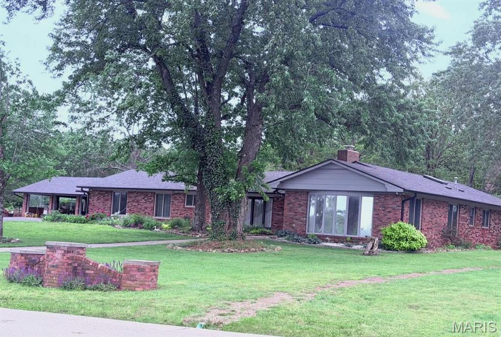 The Home  YOU have been waiting for!    All Brick,  over 4000 square feet,  with 5 bedrooms, and 3 bathrooms.   Several Living Room areas.  with a great updated kitchen,  with custom cabinets, and grantite Counter tops,   Great appliances,  Refrigerator, stove, dishwasher, two microwaves and a trash compactor. Anderson Windows.  Two skylights!  There is a very large Rec Room,  and four bays in the garage.  Motion lights and a security  system provide for safety and security. Internet is hooked up to Starlink. The Roof and the hot water heater are less than a year old, roof has new gutter guards..   Split bedrooms,  with two on one side of the house and three on the other.  Perfect for large families, or  even an in-law section.   Any size family would love all of the space and closets and storage found inside this large home.   The two fireplaces are wood burning.  One has an electric insert for instant heat.  There are three separate furnaces, and three separate Air units.  Zone heat and air provides savings on heat and air bills.  A new sliding door takes you out to a large Courtyard , at the back of the house,  the lot is over two acres,  covered with large trees and many flowers, and a storage shed.  The driveways have been recently sealed.  The view out front is so peaceful,  you will spend many hours just looking at the water, or watching the geese,  or going out to catch a fish or two.  There is a walking trail, fishing, and a on site yard waste dump. This home has so much to offer, Nestled among several other beautiful homes around the lakes. Just outside of town, off of North Highway 5.   Don't delay schedule a showing today.