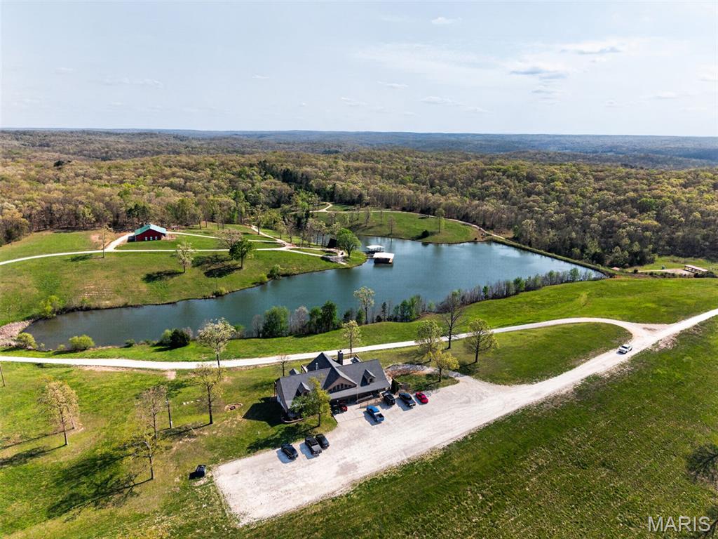 Welcome to 4273 Highway 47 in Lonedell, Missouri, an extraordinary 214+/- acre private resort and turnkey sporting destination just 45 minutes south of South County. From the moment you arrive, the setting is nothing short of breathtaking with gated entry, rolling hills, manicured grounds, and a spring fed, stocked 8-acre lake that serves as the centerpiece of this one of a kind property.

Perched above the landscape, the 6,000 sq ft ski lodge inspired clubhouse delivers an unforgettable first impression. Inside, soaring wood beamed ceilings, a dramatic stone fireplace, and walls of windows frame panoramic views of the lake and countryside creating a warm, upscale atmosphere ideal for entertaining, events, or private retreats. The space seamlessly connects to the pro shop, and expansive event areas designed to host everything from corporate outings to private gatherings. Attached lodging offers 2 bedrooms and 1 bath, providing convenience for overnight guests or owners.

Step outside and the experience continues. A wraparound deck and covered patio overlook the water, offering the perfect setting for relaxed evenings, client events, weddings, or post shoot gatherings. Down at the shoreline, two private covered docks with seating invites fishing, conversation, and quiet moments on the water with picturesque views of the sunset.

Tucked along the lake’s edge, a charming A-frame cabin offers a true retreat experience with 1 bedroom, 1 bath, and direct access to the water, a rare and highly desirable amenity for guests.  

Crowning the hillside above the lake, a striking 60x60 under-roof red barn offers both visual impact and exceptional functionality. Ideal for equipment storage, workshop space, or future expansion, it anchors the property with classic charm and practical versatility.

The land itself is meticulously curated for outdoor recreation. Featuring a 15-station sporting clays course woven through mature timber, multiple firearm bays, a 300 yard rifle range, archery range, and open meadows, this property delivers a world class sporting environment with both beauty and functionality. A large barn/workshop provides ample storage and operational support for equipment and maintenance.

Currently operating as a members-only sportsman’s club and event venue, this property offers immediate income potential with an established clientele while also presenting endless opportunities for expansion, redevelopment, or conversion into a private estate or luxury retreat.

Properties of this scale, quality, and versatility rarely come to market. This is more than land, it’s an experience, a business, and a legacy. Schedule your private tour today.