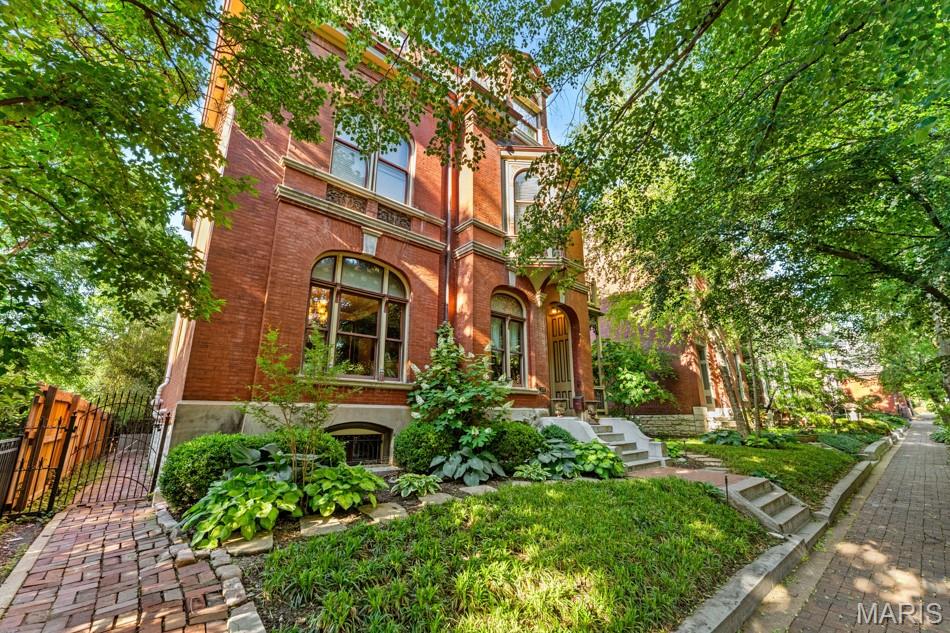 Built in 1884 for Civil War Major Leo Rassieur, this Victorian Manse in the heart of Lafayette Square blends historic character with modern comfort. The property includes the main residence, a two-story carriage house, and a garage, all set on beautifully landscaped grounds. The gracious living room overlooks the tree-lined street and showcases a large stained-glass window and one of many original tiled fireplaces. Hardwood floors, intricate millwork, pocket doors, and multiple fireplaces continue throughout. Formal living, parlor, and dining rooms offer effortless flow for entertaining. The chef’s kitchen features high-end appliances, generous cabinetry, a center island, a breakfast area, and a butler’s pantry with an adjacent powder room and bar. The primary suite includes abundant closets, a bath with heated floors, and a soaking tub beneath a bay window. Upstairs are three additional bedrooms, including one en-suite, plus a third-level bedroom, bath, and office. Second-floor laundry, a two-car garage, and a carriage house with an apartment and gym complete this property. Just steps from Lafayette Square Park and its vibrant dining scene. Lafayette Square Pool membership included (current waitlist approx. 5 years).