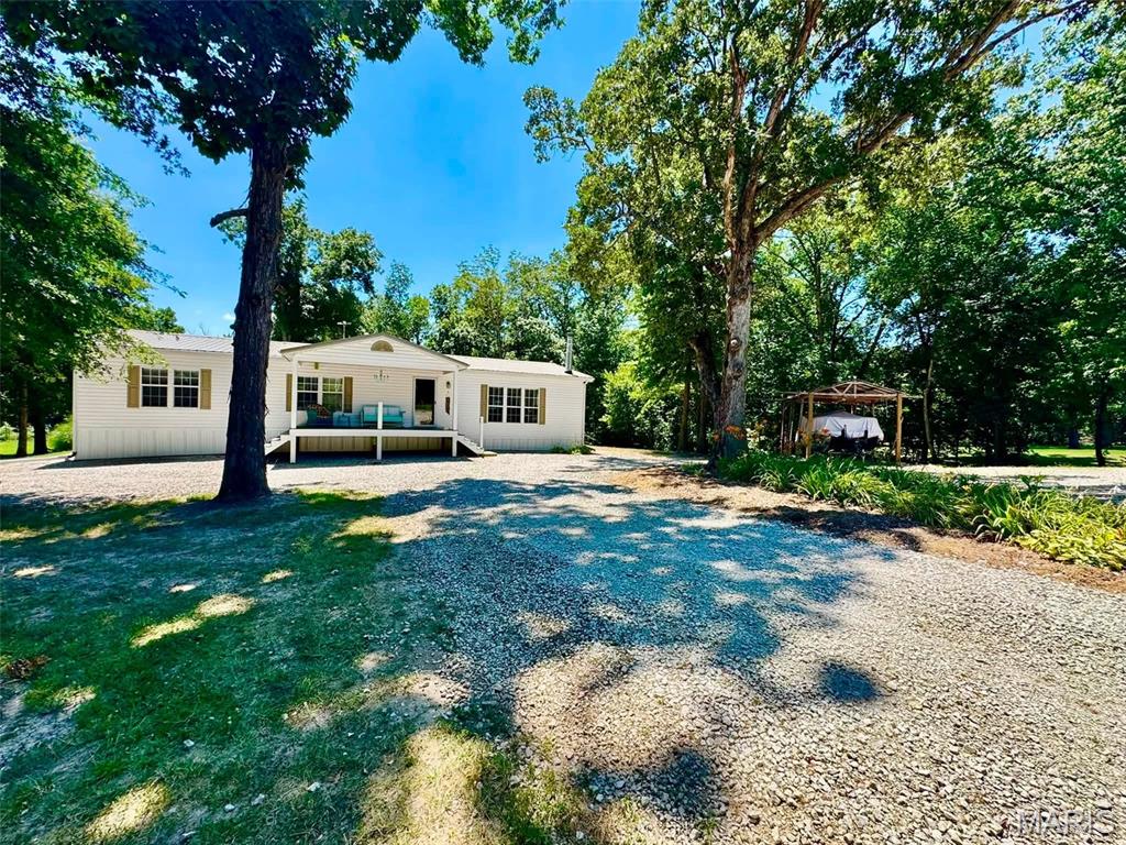 Welcome to your secluded 5+ acres of country/lake life paradise! If the location itself isn't enough, tack on a beautiful 3-bed, 2-bath, 1,800sqft home, 60x40 shop, & an RV hookup area to boot. To further enhance this deal of the year, seller is willing to sell the property turn-key & allow appliances plus nearly all furniture stay if new owner so wishes! Additional property features include: a massive primary bathroom suite you have to see to believe, real wood-burning living room fireplace, tall ceilings, private fire pit, boat storage, & cleared trails to a relaxing creek on the premises. Your metal shop is insulated, concrete floor, oversized entrance/exit doors, plus has a 200amp service & wood burning stove. Schedule the appointment to see it & you'll know its home