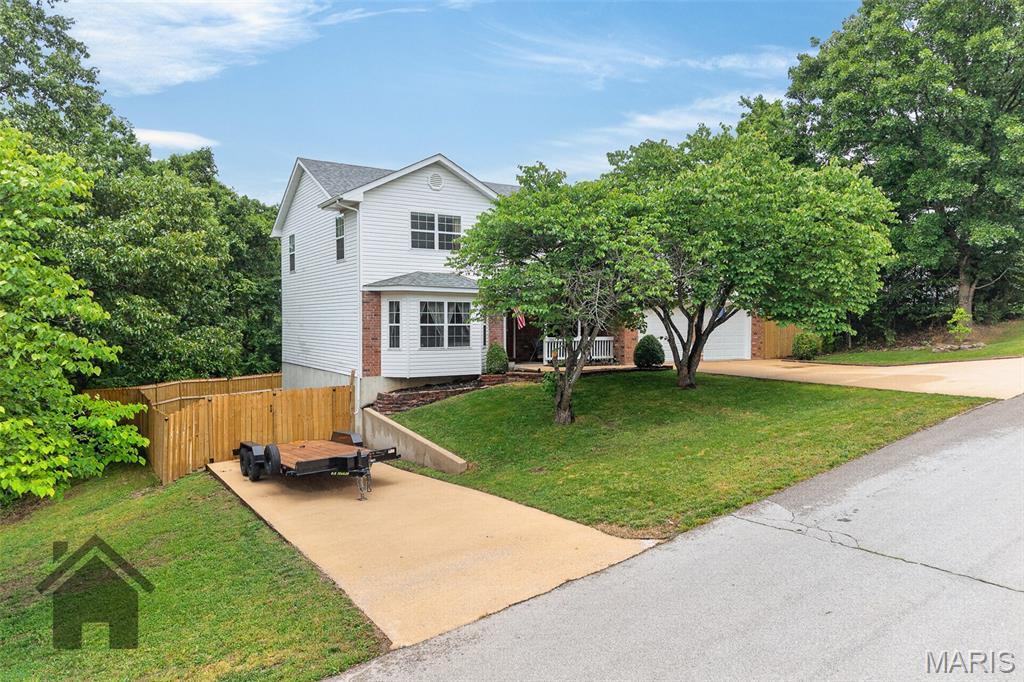 Welcome home to this wonderfully cared-for and strategically updated 4-bedroom, 3.5-bath two-story home over a finished walk-out basement, located in the Waynesville School District and just a short drive to the main gate of Fort Leonard Wood! Highlight features include fresh paint throughout, a privacy-fenced backyard, two driveways, storage shed, new kitchen faucet, new garbage disposal, new stove, updated ceiling fans, and light fixtures with remote and smart Wi-Fi access throughout. Step inside from the covered front porch and you’ll be greeted by beautiful light wood flooring that carries through the dining room and kitchen. The living room is carpeted for comfort and features a timeless bay-style window that brings in plenty of natural light. The kitchen offers medium oak cabinetry, abundant white countertop space, a full appliance suite, closet pantry, and an attached formal dining room. A half bathroom and laundry area are also conveniently located on the main level. Upstairs, the primary bedroom suite features a new ceiling fan with remote, walk-in closet, and attached bathroom with a single vanity and shower/tub combo. Down the hall, you’ll find two additional guest bedrooms, including one with a walk-in closet and another with an oversized closet, along with a full guest bathroom featuring double sinks, generous counter space, and a shower/tub insert.
The finished walk-out basement offers a large family room, perfect for hosting, relaxing, or entertaining guests. A 4th bedroom, full bathroom, and utility closet complete the lower level. Step outside through the remodeled back patio space to enjoy the newly privacy-fenced backyard with a storage shed, ideal for lawn equipment, toys, and outdoor storage. With two driveways offering flexible parking for everyday vehicles, a boat, RV, camper, or trailer, this home is as functional as it is inviting. Pride of ownership is evident throughout, and this move-in ready home is sure to impress. Quiet neighborhood and proximity to shopping and work makes the location unbeatable! Schedule your showing today! *INQUIRE ABOUT A VA ASSUMABLE LOAN AT A 5.6% INTEREST RATE*!!!