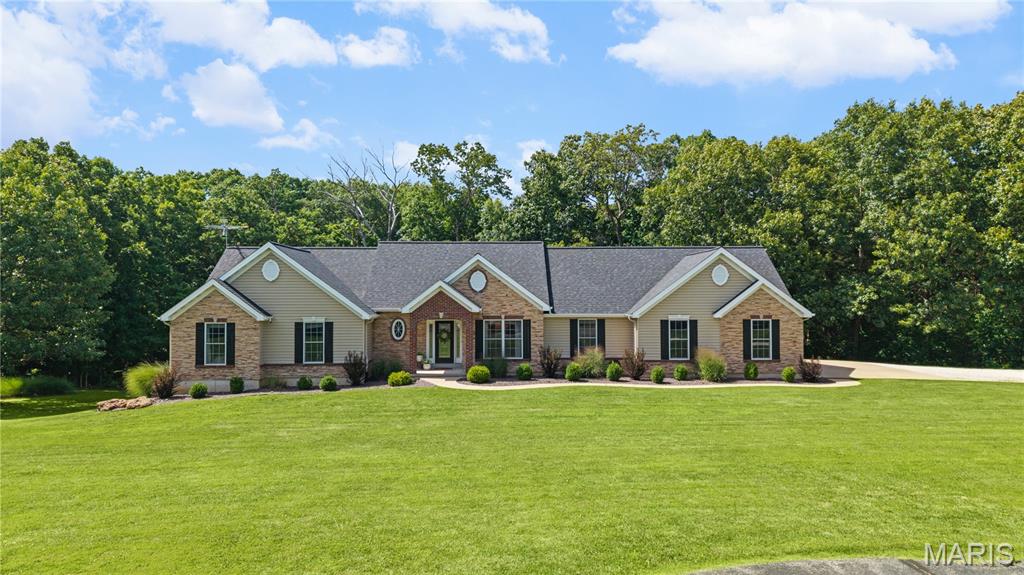 Open House 7/12 12-2pm * Nestled on a private 3-acre setting, this beautiful home delivers the perfect combination of luxury finishes, functional living spaces, and inviting outdoor living throughout. Built on a solid 9-foot pour foundation, the home offers soaring 9-foot ceilings in the kitchen and dining areas and 8-foot ceilings throughout the rest of the main level. Step through the front door to discover a great room anchored by a see-thru fireplace, creating a warm first impression that flows seamlessly into the vaulted, screened-in sunroom and deck beyond. Designed with both everyday living and entertaining in mind, the main level offers a versatile flex room ideal for a home office or formal dining room, along with convenient main floor laundry. The gourmet kitchen serves as the heart of the home, featuring custom 36" white cabinetry, quartzite countertops, a farmhouse sink with touchless faucet, stainless steel appliances, a center island, and a walk-in pantry. Retreat to the primary ensuite, offering a true escape at the end of the day. The luxurious bath features a soaking tub, separate shower, dual vanities, and a spacious walk-in closet. Two additional generously sized bedrooms and a full bath complete the main level living space. The partially finished walkout basement offers endless opportunity to expand your living space, featuring a rec room, 4th bedroom, wet bar, and dedicated exercise area, plus ample storage space. Step outside to one of the home's standout features, a deck and covered patio overlooking the pool, creating the perfect setting for morning coffee and effortless entertaining year-round, all set on a sprawling 3-acre lot. Additional highlights include an oversized 3-car attached garage, new roof in 2023, new fascia in 2026, and Brightspeed fiber optic internet available to the home. Beautifully finished, thoughtfully designed, and move-in ready!