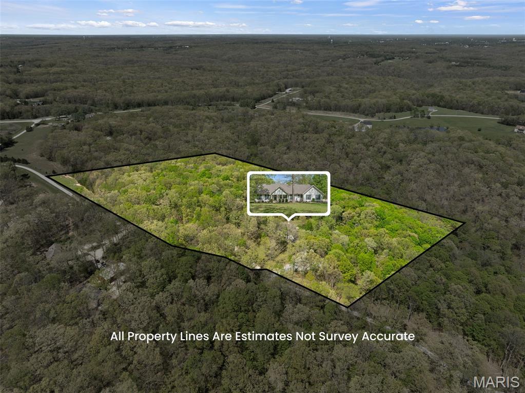 Tucked away on 15 private wooded acres, this custom-built retreat offers the perfect balance of peaceful country living and modern comfort. Surrounded by abundant wildlife—including deer, turkey, fox, and a variety of birds—this property is a true escape for nature lovers, outdoor enthusiasts, and those seeking privacy and serenity.

With approximately 2,970 square feet of finished living space, this beautifully maintained 4-bedroom, 3-bath home features warm wood flooring throughout much of the main level and a thoughtfully designed layout ideal for everyday living and entertaining. The spacious Great Room is highlighted by a striking masonry fireplace and French doors opening to a bright sunroom with scenic backyard views.

The kitchen is both functional and inviting, featuring granite countertops, a breakfast bar, double wall ovens, and a charming bay window overlooking the expansive composite deck and gazebo. Additional main-level spaces include a breakfast room, formal dining room, and cozy sitting room. The main-floor primary suite and laundry room add convenience and ease.

Upstairs, a beautifully crafted wood staircase leads to two generously sized bedrooms and a full bath—perfect for family or guests. The oversized side-entry 3-car garage offers ample space for vehicles, hobbies, or equipment, while the walk-out lower level includes rough-in plumbing, additional washer/dryer hookups, and abundant storage with endless potential for future finishing.

Step outside to enjoy peaceful mornings, serene evenings, and the beauty of your own wooded paradise from the spacious deck and gazebo. Offering a rare combination of privacy, natural beauty, and convenience, this exceptional property feels worlds away while being just 10 minutes from shopping, dining, schools, and everyday amenities.

Property Highlights
• 15 private wooded acres with abundant wildlife, hunting permitted
• Approximately 2,970 sq. ft. of finished living space
• 4 bedrooms | 3 full baths
• Stunning masonry wood-burning fireplace
• Sunroom with scenic backyard views
• Granite countertops & double wall ovens
• Spacious composite deck with gazebo
• Main-floor primary suite & laundry
• Oversized side-entry 3-car garage
• Walk-out basement with rough-in plumbing
• Additional washer/dryer hookups in lower level
• Primarily wood flooring throughout
• Peaceful rural setting just 10 minutes from town conveniences

See the “Home Improvements” list in supplements. Back on market through no fault of the seller.