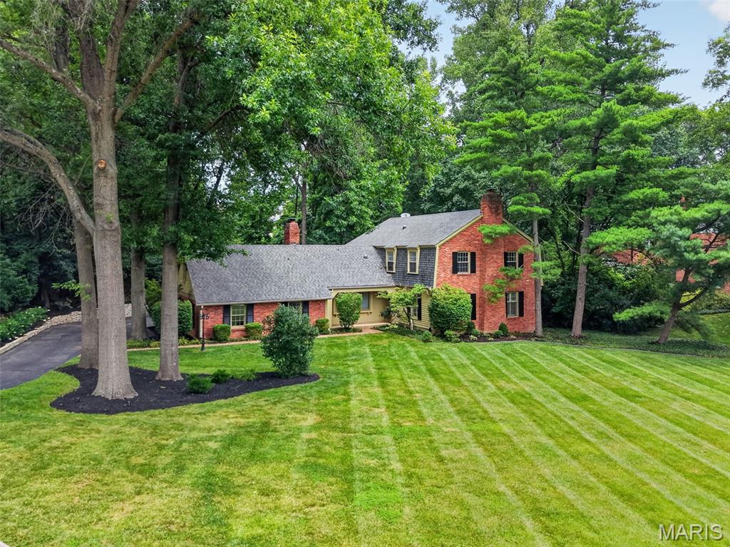 Experience timeless elegance in this exceptional 2 story estate offering over 4570 square feet of luxury living on a private 1.19 acre wooded lot in prestigious Dunleith subdivision within the highly sought after Ladue School District. This impressive home features 3 bedrooms, 3.5 baths, an oversized rear entry 2 car garage with EV charging, smart home automation with integrated control of lighting, window shades, door locks, security cameras, exhaust fans, water leak detection and irrigation system, plus an extraordinary outdoor retreat designed for both entertaining and everyday living. The entry foyer opens to beautifully appointed living spaces with rich wood flooring, crown molding, and fireplaces in both the living room and great room. The great room features a beamed ceiling, custom built in bookcases, wet bar, and opens to the vaulted sunroom surrounded by sliding glass doors overlooking the spectacular backyard. The chef's kitchen is equipped with granite countertops, breakfast bar, built in pantry, Wolf Professional dual fuel range, Viking Professional refrigerator, Sub Zero refrigerator drawers, Reverse Osmosis water system, and opens to the breakfast room with beverage refrigerator, ice maker, and access to the composite deck. The elegant dining room is enhanced with a bay window, crown molding, and wainscoting. The luxurious primary suite offers LVP flooring, 2 walk in closets with custom organizers, including a dressing area with vanity, and a beautifully updated bath with heated tile floors, double vanities, and an oversized walk in shower with dual shower heads. 2 additional bedrooms feature LVP flooring and custom closet organizers, while the spacious laundry room with built in cabinetry and utility sink was originally designed as a fourth bedroom, providing future flexibility. The finished lower level includes a family room, office or fitness room, full bath, and recreation room with electric fireplace, granite bar, custom cabinetry, wine refrigerator, and built in wine rack. Step outside to your own private resort featuring a heated 26,000 gallon salt water pool, composite deck, outdoor fireplace with built in gas grill, pizza oven, professional landscaping, and mature trees that create exceptional privacy. Combining exquisite craftsmanship, modern technology, luxurious finishes, and an unbeatable location, this remarkable property offers an extraordinary lifestyle in one of the area's most desirable neighborhoods.
