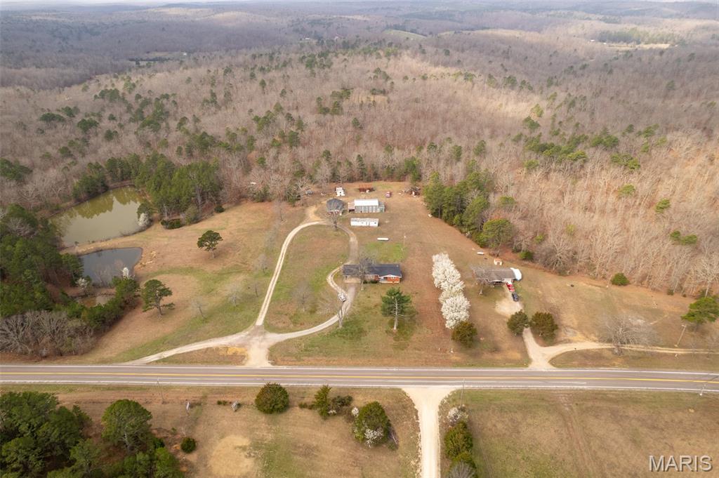 This is a rare opportunity to purchase a beautiful 46 m/l acres of the Ozarks.  The property consists of approximately 5 acres cleared with a home, a shop, a barn and multiple storage buildings.  The home has 1428 sf, 3 bedrooms, 2 full baths, large kitchen, dining and living rooms and a large, covered deck as well as a full, unfinished basement.  The main house and the 25 X 45 garage/shop both got new roofs installed in 2025.  The home has an all brick exterior.  The property has an approximately 500 ft, drilled well.  The main home had new HVAC units installed in 2024.  There are 5 ponds of varying sizes which are stocked with bass, catfish, perch and crappie.  The remaining acreage has marketable timber, trails, some wonderful building spots, tons of whitetail deer, turkey and other small game.  The location just 4 miles south of Ellington offers Hwy 21 frontage and is in close proximity to Clearwater lake, Black River, Current river, Miller lake, Big Springs State park and 1000's of acres of National Forests.  Whether looking for a homestead or an investment property, this Ozark beauty fits the bill.  Schedule your appointment today for a personal viewing of this magnificent property.