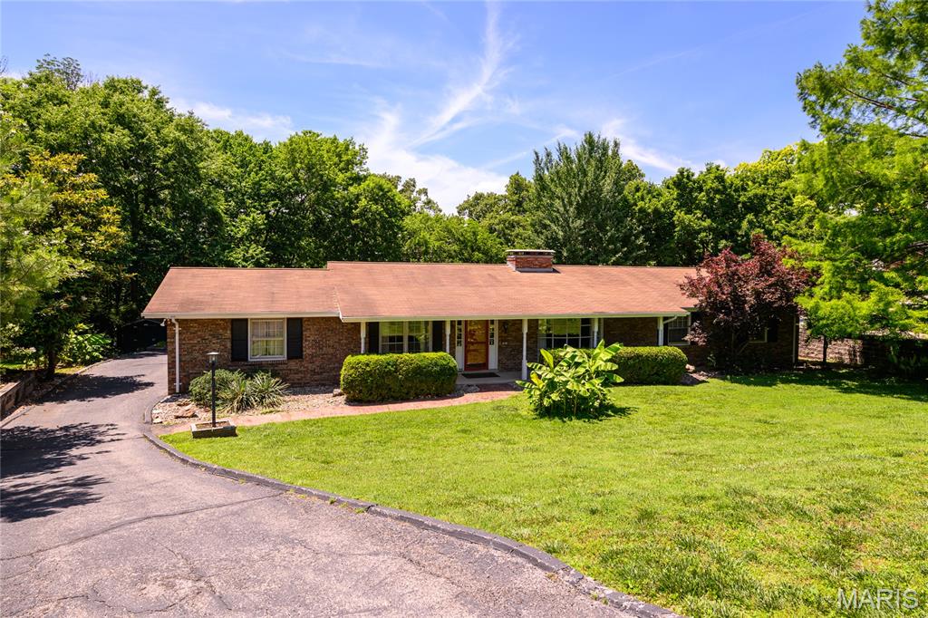This beautiful mid-century gem sets on a beautiful half acre with lots of privacy in the rear backing to common ground. The entry foyer is flanked with the dining room and sunken living room with a fantastic bay window. The fireplace in the living room opens to the family room, too. The kitchen has been updated over the years with beautiful slab oak cabinetry, and it opens to the large family room that walks out to a covered patio overlooking the backyard. There are 3 bedrooms and 2 full baths. The hall bathroom has been updated and even though the primary bathroom hasn't been recently updated, there is plenty of room to add your own personal touches! The lower level is finished with a third fireplace in the rec room, a den, a bathroom, and a dark room for the photography enthusiast.