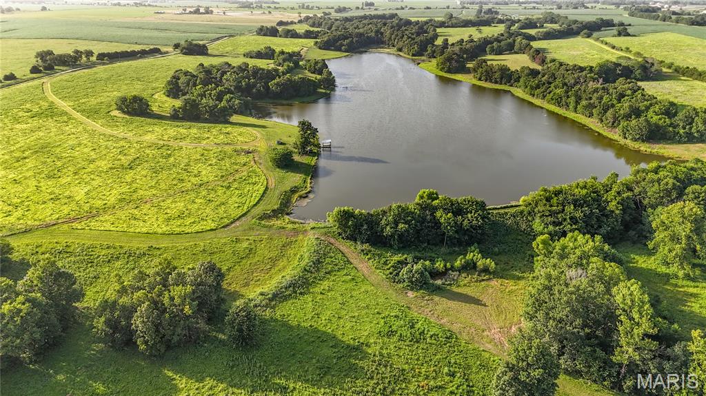 Some farms simply check the boxes. Others leave a lasting impression the moment you set foot on the property. This exceptional 468.1± acre recreational and investment farm in the heart of Callaway County, Missouri, is unquestionably the latter. Designed by nature and enhanced through thoughtful management, this property offers the rare combination of exceptional wildlife habitat, significant annual income, premier fishing, and the kind of privacy that serious hunters spend years searching for. Large neighboring landowners maintain very light hunting pressure, creating an environment where mature whitetails can consistently reach their full potential. From the rolling hardwood ridges and secluded timber draws to the expansive CRP fields and strategically positioned food plot locations, every acre contributes to a landscape built to hold and grow trophy deer. Add in a thriving turkey population, and you'll quickly understand why properties of this caliber rarely become available. One of the property's defining features is its incredible water. A breathtaking 26-acre lake serves as the centerpiece of the farm, offering outstanding bass, crappie, and bluegill fishing while providing exceptional habitat for migrating waterfowl. Whether you're watching mallards work the decoys on a crisp December morning or enjoying an evening on the water with family, this lake creates opportunities few recreational properties can match. A second, approximately 8-acre stocked lake offers additional fishing, scenic beauty, and year-round enjoyment. As impressive as the recreational opportunities are, the investment side of this farm is equally attractive. Approximately 175.67 acres are enrolled in the Conservation Reserve Program, generating an annual payment of $32,973 while simultaneously providing ideal bedding cover, nesting habitat, and natural travel corridors for wildlife. This dependable income helps offset ownership costs without sacrificing the property's recreational appeal. There's an older 3 bed/4 bath farmhouse that is currently useable, but could use some restoration or be torn down. In the vicinity of the house there are multiple outbuildings for storage. Finding a large contiguous tract with this combination of income, habitat diversity, water resources, and proven hunting potential is increasingly rare in Central Missouri. Whether your vision is chasing mature whitetails each fall, enjoying first-class fishing and waterfowl hunting, or owning a legacy investment that can be enjoyed for generations, this remarkable Callaway County farm represents an opportunity that seldom reaches the open market. This is more than a farm—it's the kind of property that becomes part of a family's legacy.