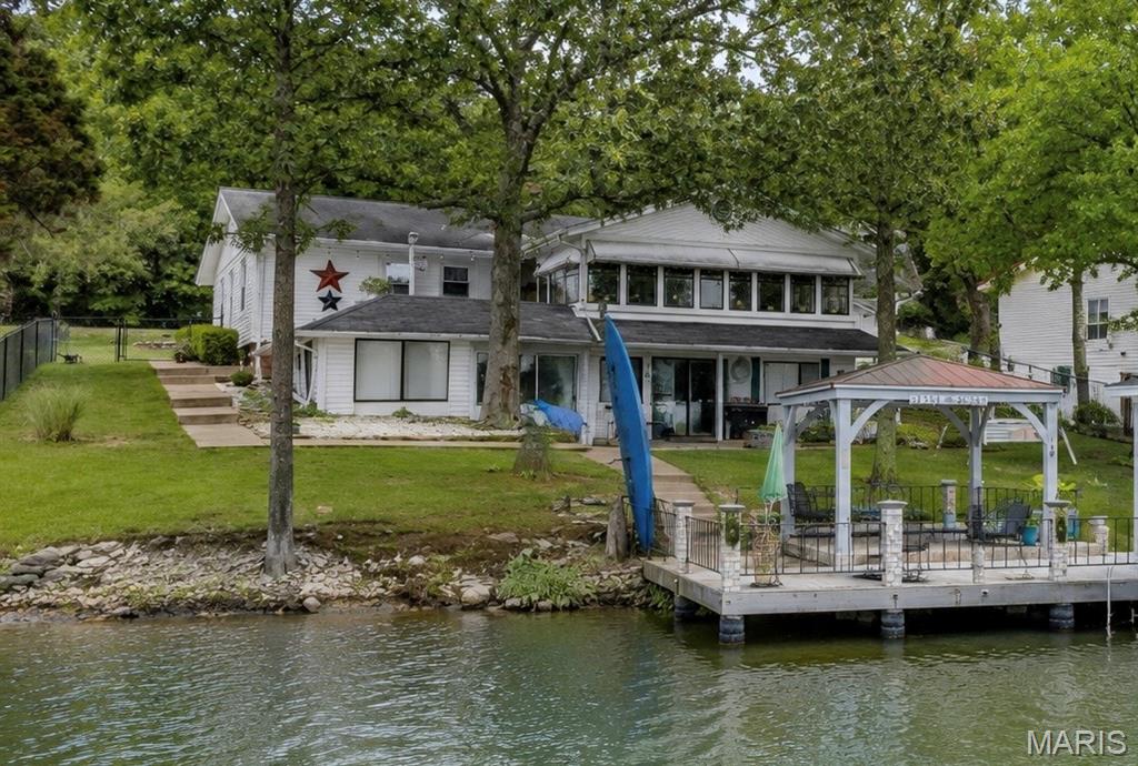Lake days, sunset cruises, and unforgettable views await. Situated on the shores of Lac Carmel in Terre Du Lac, this incredible waterfront retreat comes complete with your own boat, covered dock, and everything you need to start enjoying lake life from day one. Whether you're spending the afternoon on the water, entertaining under the covered lakeside pavilion, relaxing on the separate deck, or simply taking in the breathtaking views, every day here feels like a vacation.

Inside, walls of windows showcase spectacular lake views and flood the home with natural light, creating a stunning backdrop throughout the main living spaces. The beautifully updated kitchen features granite countertops, abundant cabinetry, a large center island, and opens seamlessly to the family room, making it the perfect place to gather after a day on the lake. Two fireplaces create warm and inviting spaces to relax, while the expansive lakeside living room offers panoramic water views you'll never tire of.

The main level features a spacious primary bedroom with a walk-in closet and convenient access to the attached laundry room. A second bedroom, dedicated office, dining room, and a beautifully updated bathroom with a custom tiled walk-in shower complete the main level, offering the convenience of one-level living.

The walkout lower level provides an oversized third bedroom with its own private access to a full bathroom, along with two additional finished bonus rooms not reflected on the floor plan. One includes a second washer and dryer hookup with additional storage, while the other is the perfect place to organize life jackets, fishing gear, boating equipment, and all of your lake essentials.

Outside is where this property truly shines. The rare level backyard makes getting to the water effortless, a feature that's hard to find on the lake. Spend evenings gathered beneath the covered lakeside entertaining area, unwind on the separate deck overlooking the water, or step onto your covered dock and head out for a cruise. The boat is included, making this a truly turnkey waterfront opportunity where all that's missing is you.

With over 2,100 square feet of living space, an attached two-car garage, an updated kitchen, main-level laundry, two fireplaces, incredible outdoor entertaining spaces, breathtaking lake views, a covered dock, and the boat included in the sale, this is more than just a home. It is your chance to experience lake living exactly the way it was meant to be.
