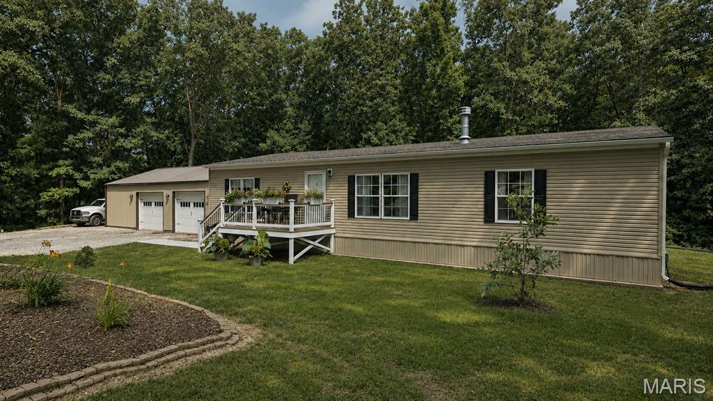 Welcome to peaceful country living! This well-maintained Fleetwood Sandalwood XL manufactured home is permanently set on a concrete slab and offers 3 bedrooms, 2 bathrooms, and a desirable split bedroom floor plan on 16.49 acres. Inside, you'll find new carpet and laminate flooring, a spacious family room with a cozy wood burning fireplace, the kitchen has a breakfast bar plenty of cabinet space and additional dining. The primary suite features double sinks and a custom walk-in shower. Recent updates include a newer roof and water heater, providing added peace of mind.

Outside, the property is equipped for work, recreation, or hobby farming. A massive 60' x 50' barn with a 60' x 14' lean to provides exceptional storage and workspace, while the detached 30' x 40' garage features a wood burning furnace electric heater and a cook stove. Additional highlights include a chicken house with enclosed pen, garden area, fruit trees, blackberry bushes, and a 50-amp RV hookup. Deer and turkey are frequent visitors, making this property ideal for hunting and nature lovers. Utilities... Montgomery County water and electric run with the road the entire distance of the property. A Branson 58 HP tractor with implements, brush hog, post hole digger, and wood splitter are available for purchase separately.