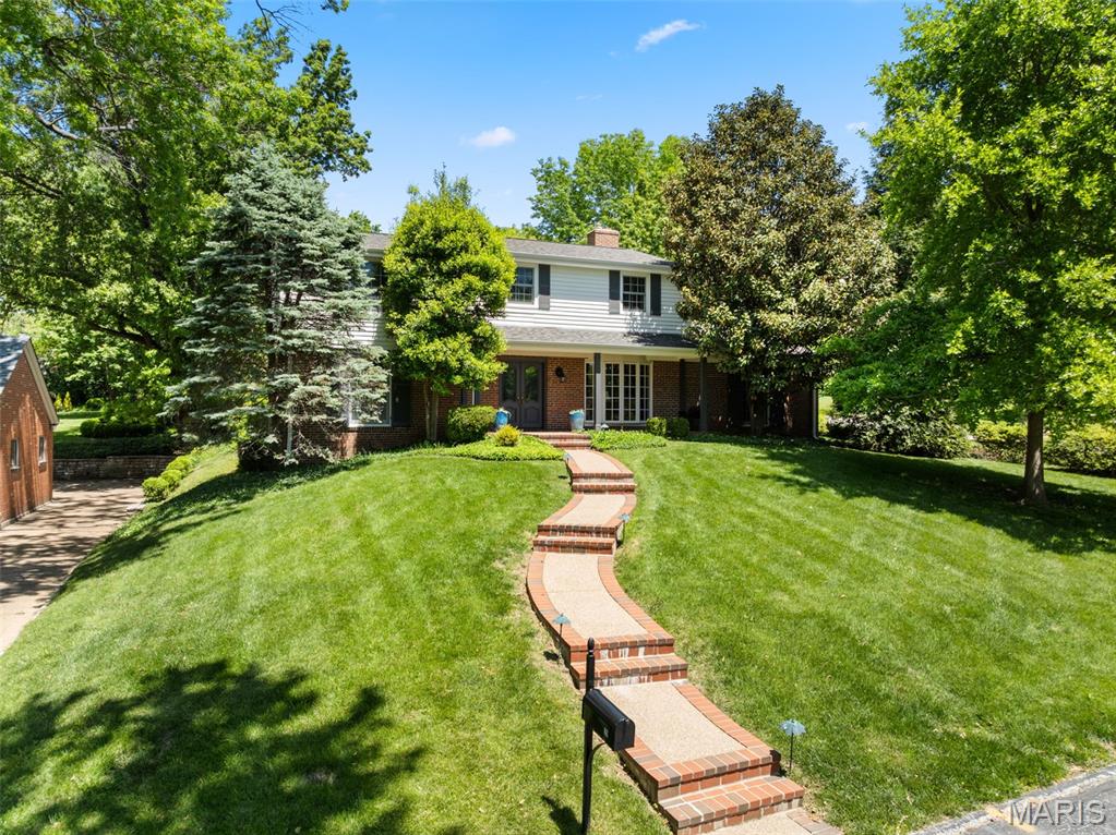 Set on an expansive, nearly half-acre lot within the highly sought-after Ladue School District, this beautifully updated 4-bedroom, 2-bath residence with a 2-car garage seamlessly blends timeless character with modern comfort. From the moment you arrive, classic louvered shutters, refined architectural details, and rich hardwood floors create an atmosphere that is both elegant and inviting. The main level offers a seamless open floor plan featuring a spacious living room, a sun-filled dining area, and a stunning kitchen complete with custom cabinetry, granite countertops, and a subway tile backsplash—all flowing effortlessly into an impressive family room with a vaulted, beamed ceiling and wood burning fireplace. A generously sized bedroom and updated full bath on the first floor provide ideal flexibility for guests or a home office. Upstairs, find three more bedrooms, including the large primary with a huge walk-in closet and easy access to the well-appointed full bath with double sinks and a separate tub and shower. Step outside to a spectacular Bluestone patio overlooking a serene, park-like backyard—perfect for relaxing or entertaining. Just minutes from great retail and dining, with easy access to major highways for convenient travel throughout the area, you can't beat the location! Showings will begin May 15th...schedule yours now!