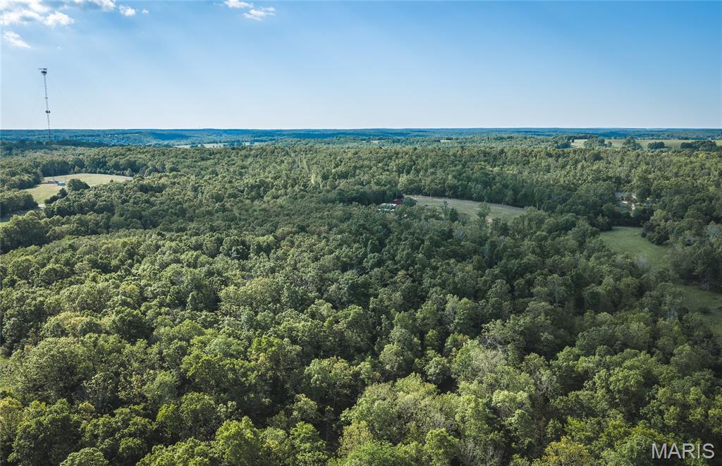 This beautiful 30-acre property offers the perfect balance of accessibility, privacy, and natural diversity. With two gated entrances off an asphalt county road, the land is easy to access while still providing multiple points of entry and flexibility for use. Each entrance features an established gravel parking and camping area, making it ideal for immediate enjoyment. The property showcases a scenic mix of rolling hills, hardwood ridges, and multiple ponds, including a larger pond believed to be spring-fed. A well-maintained trail system winds throughout the acreage, providing excellent access for recreation, hunting, or exploring. In the center of the property, a bottom field offers great potential for a food plot or could be expanded for additional open ground. Several attractive building sites are scattered across the property, including a more secluded location set back from the road for added privacy. Power is already available on-site, making future development even more convenient. Whether you're looking for a recreational retreat, hunting property, or a future homesite, this tract checks all the boxes. Conveniently located just 20 minutes from Rolla, you’ll have quick access to advanced healthcare, shopping, dining, and all the essentials while still enjoying the peace and quiet of the countryside.