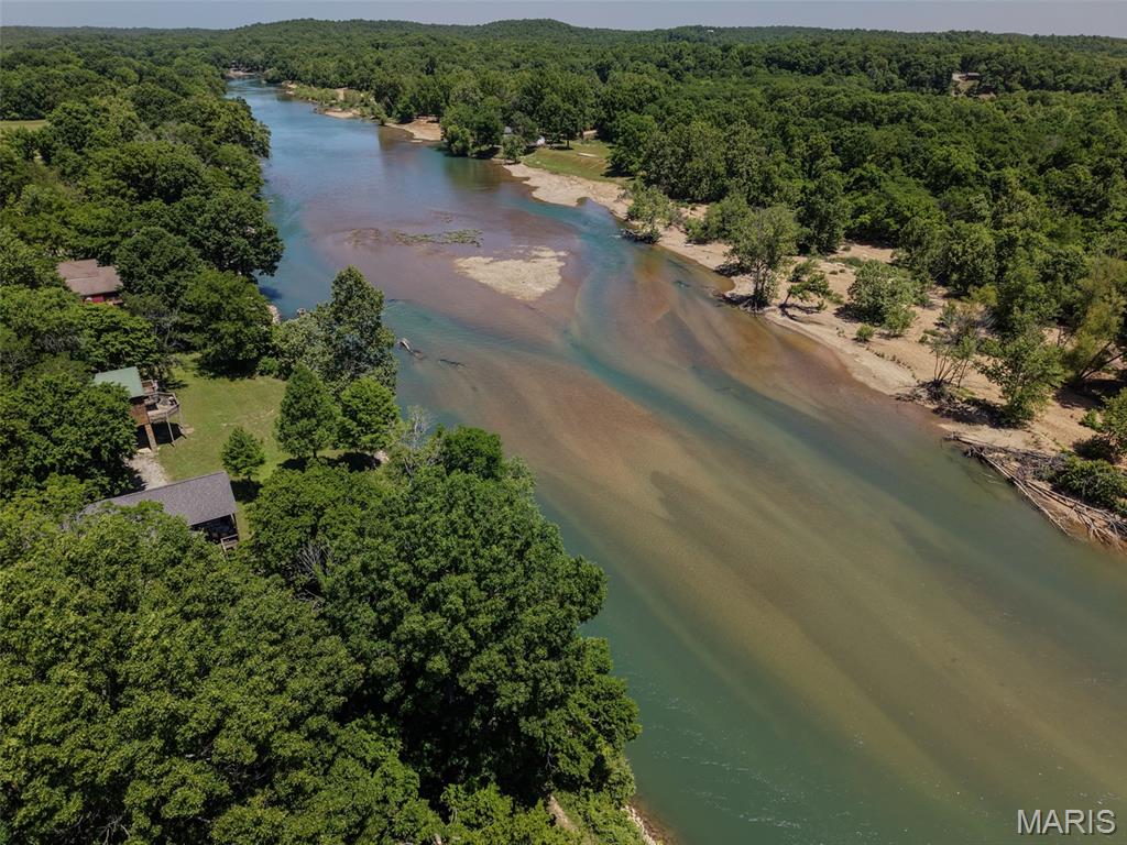 Current River Waterfront lot in Paradise Acres, Ripley County, MO
Welcome to your front-row seat on the crystalline waters of the Current River. Located in the quiet enclave of Paradise Acres in Ripley County, this is one of the last remaining undeveloped waterfront lots in the entire subdivision. Positioned just above the Arkansas state line and near the local landmark known as "Snaggy Bend," this property offers the perfect balance of water views, access and the serene, uncrowded atmosphere of the lower river. Unlike more remote tracts, the heavy lifting here is already addressed—water and electricity are available, allowing you to transition from your architectural vision to reality with ease. Whether you're planning a modern river retreat or a classic family cabin, the level terrain and established surroundings provide a foundation for your investment.
Paradise Acres is known for its small-scale, neighborly feel and its commitment to the river lifestyle. Owners here enjoy private access to a community boat launch, making it effortless to get on the water for a day of smallmouth fishing or a slow sunset cruise. This portion of the river is cherished by locals for its pace—quiet enough to hear the water over the stones, yet big enough to feel the true power of the Current.
Located just south of Doniphan, you are close enough for a quick run into town for supplies, yet far enough downstream to feel completely removed from the hustle. As one of the final opportunities to build in this sought-after development, this lot represents a rare "buy and hold" or "buy and build" scenario in one of the most stable recreational markets in the Ozarks.